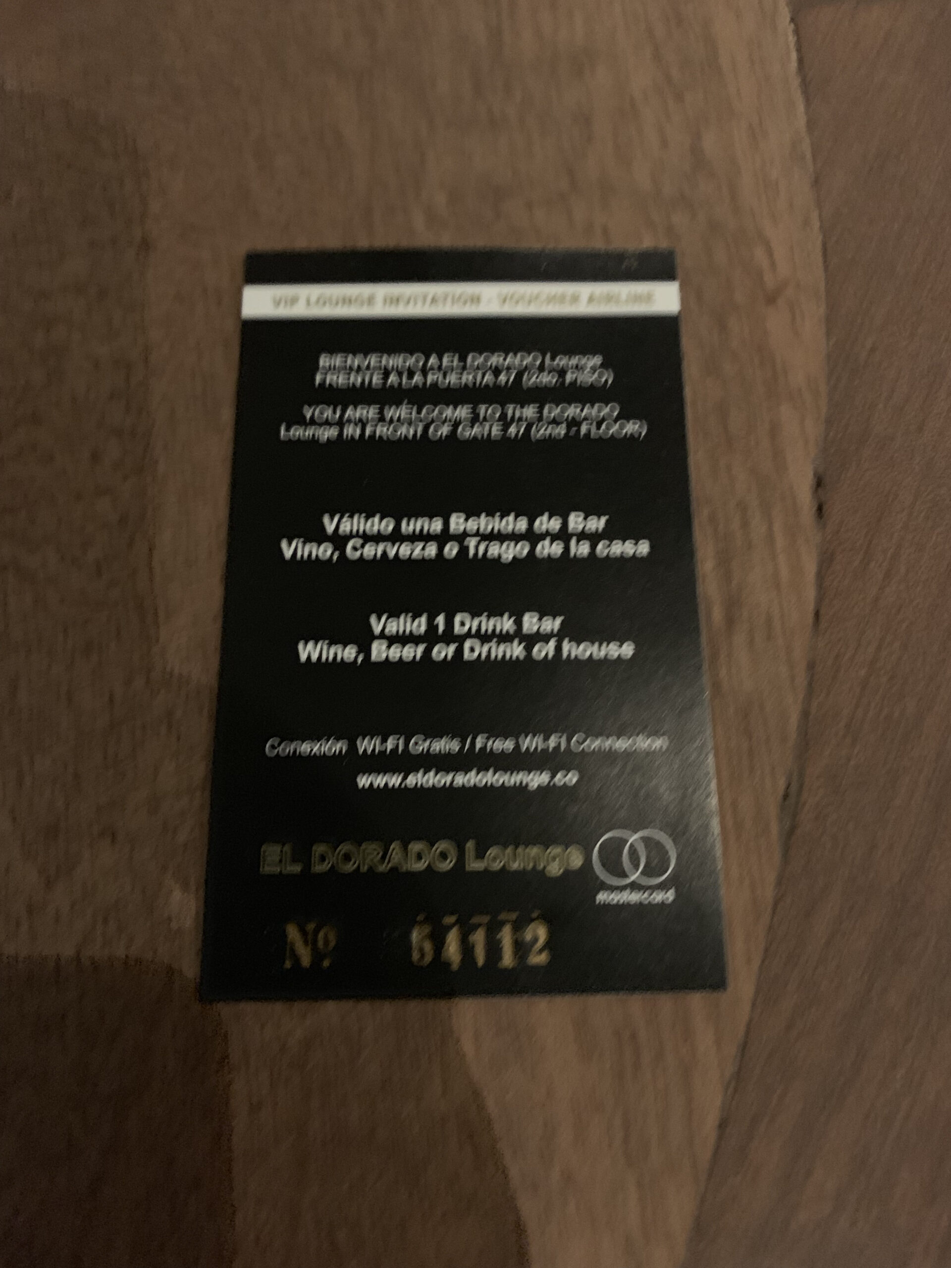 Schwarze Einladungskarte der El Dorado Lounge mit Voucher für ein Freigetränk, Nummer 64712.