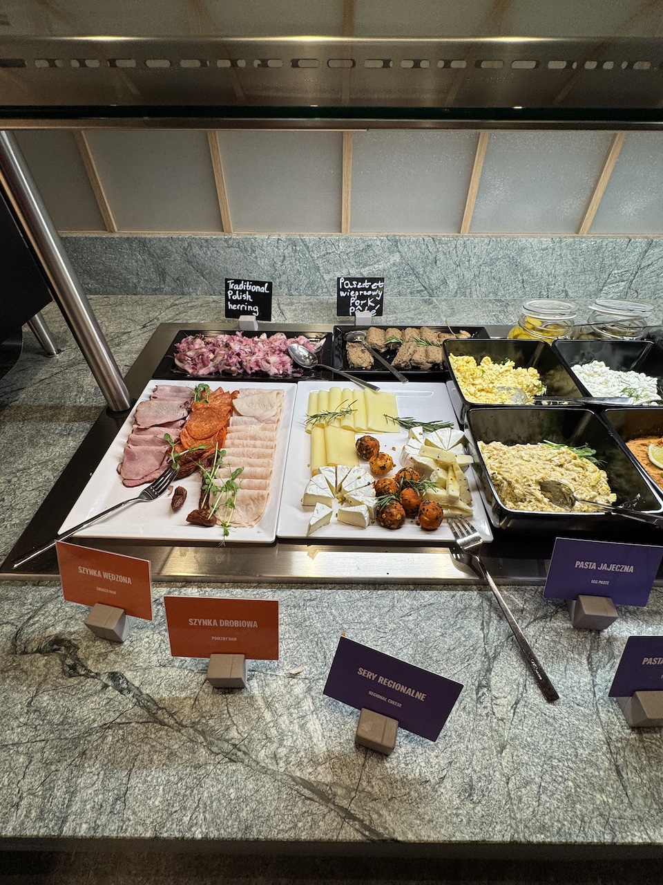 Frühstücksbuffet mit Aufschnitt, Regionalkäse, Hering, Schweinepastete und Eieraufstrichen.