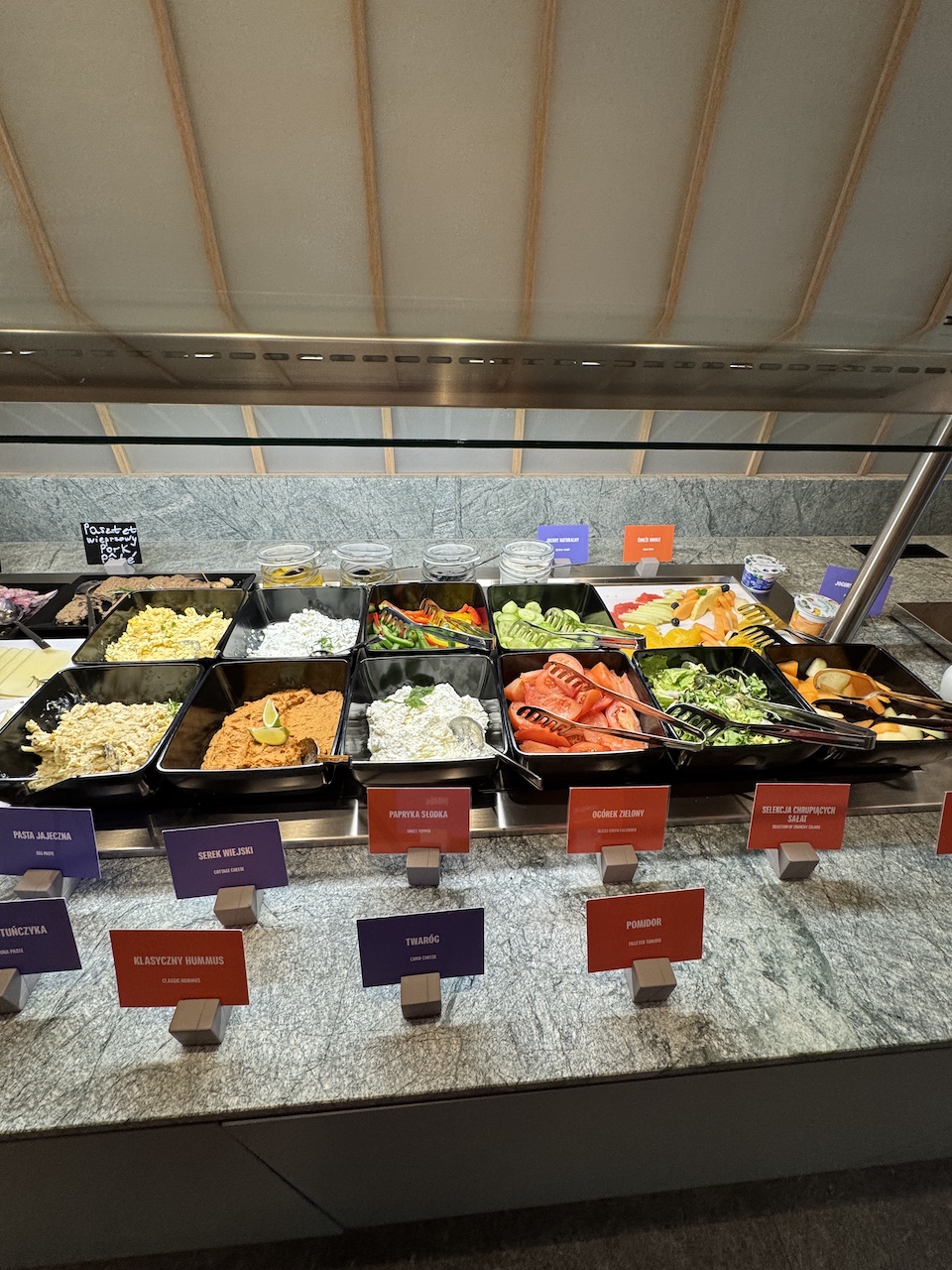 Kaltbuffet mit Aufschnitt, Hummus, Quark, Tomaten, Gurken und Salaten in schwarzen Schalen