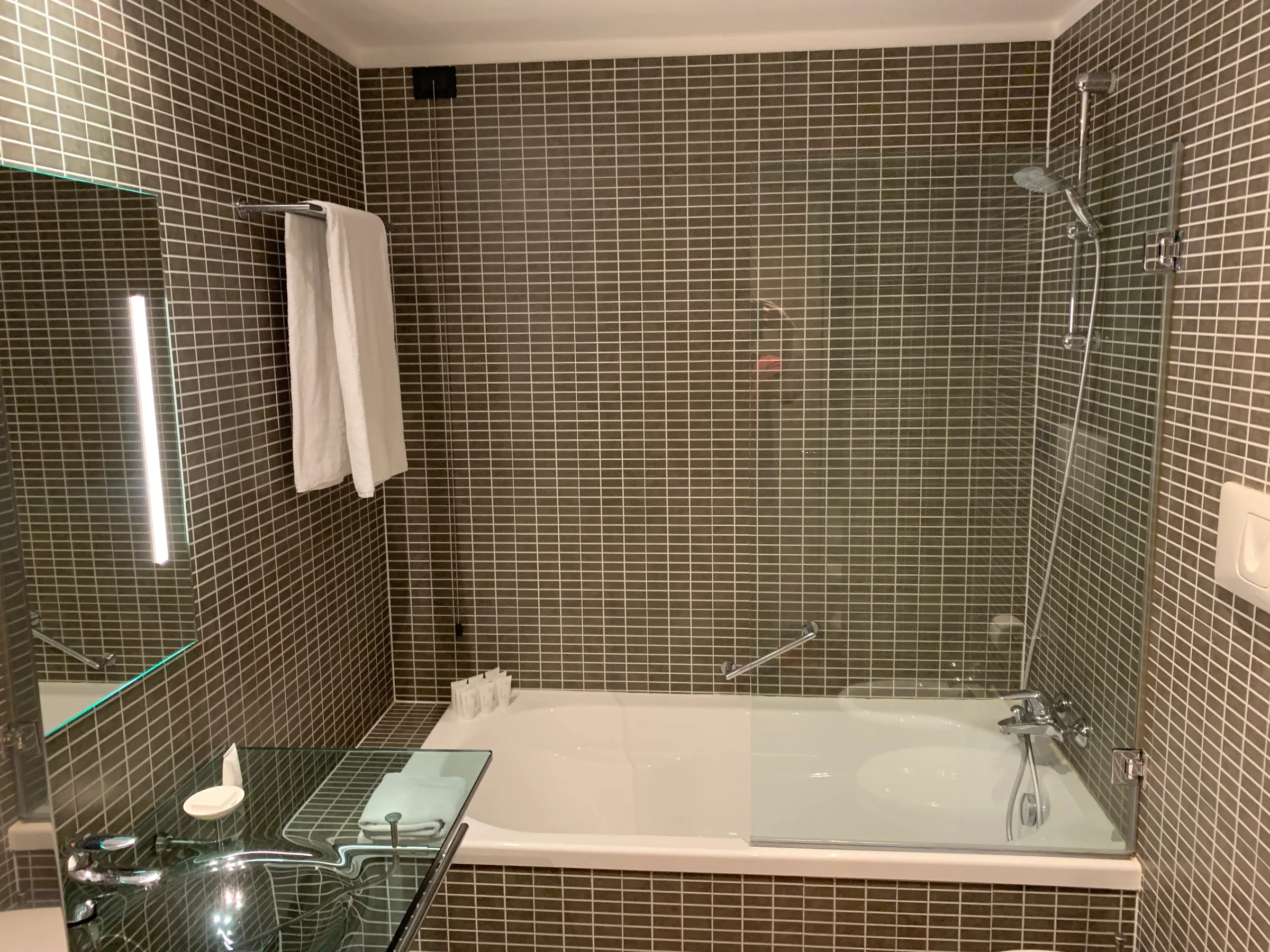 Hotelzimmer mit Doppelbett und grauem Bettbezug
