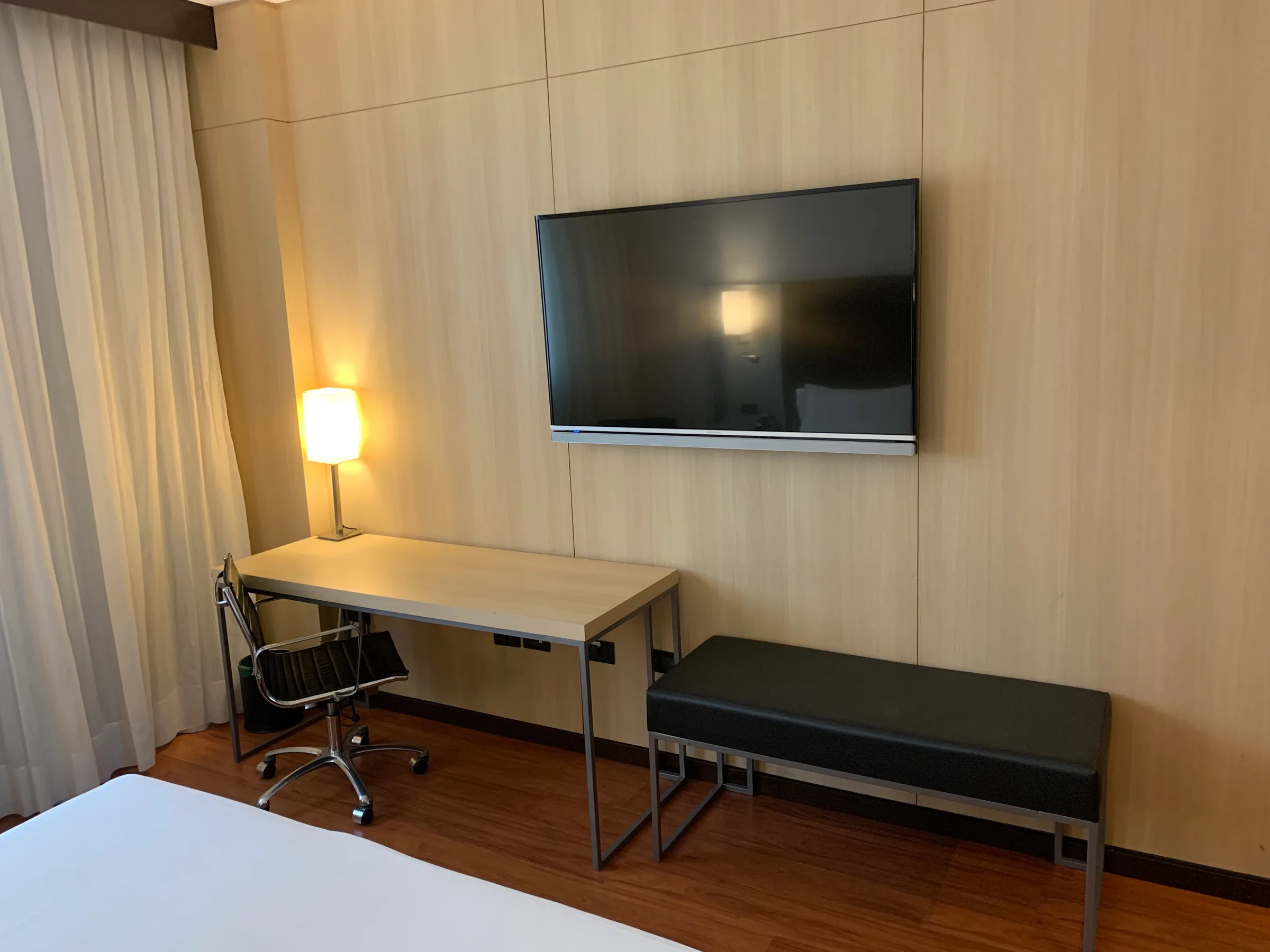 Hotelzimmer mit Doppelbett und grauem Bettbezug