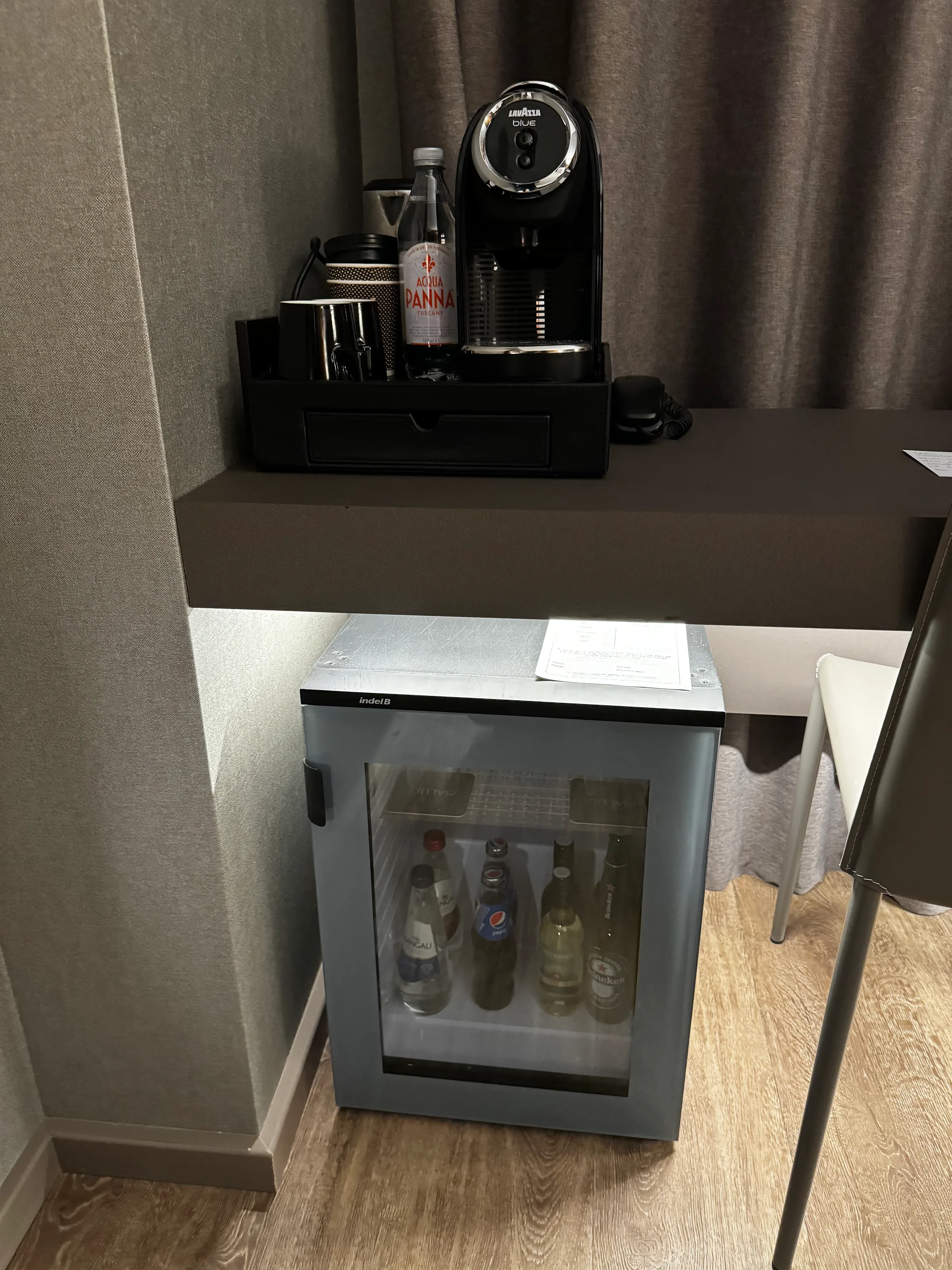 Hotelzimmer mit Doppelbett und grauem Bettbezug