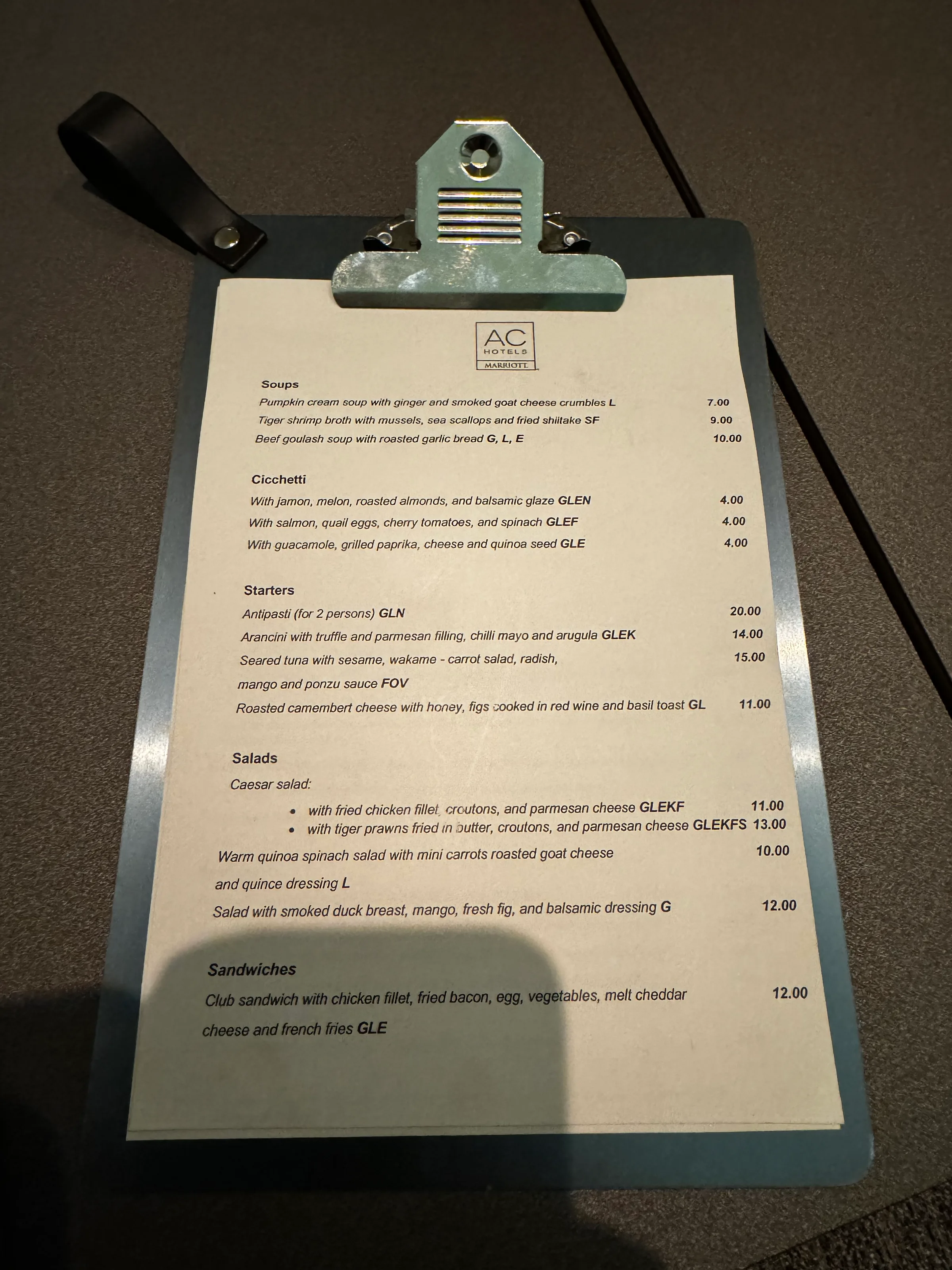 Menü mit verschiedenen Gerichten und Preisen auf einem Clipboard
