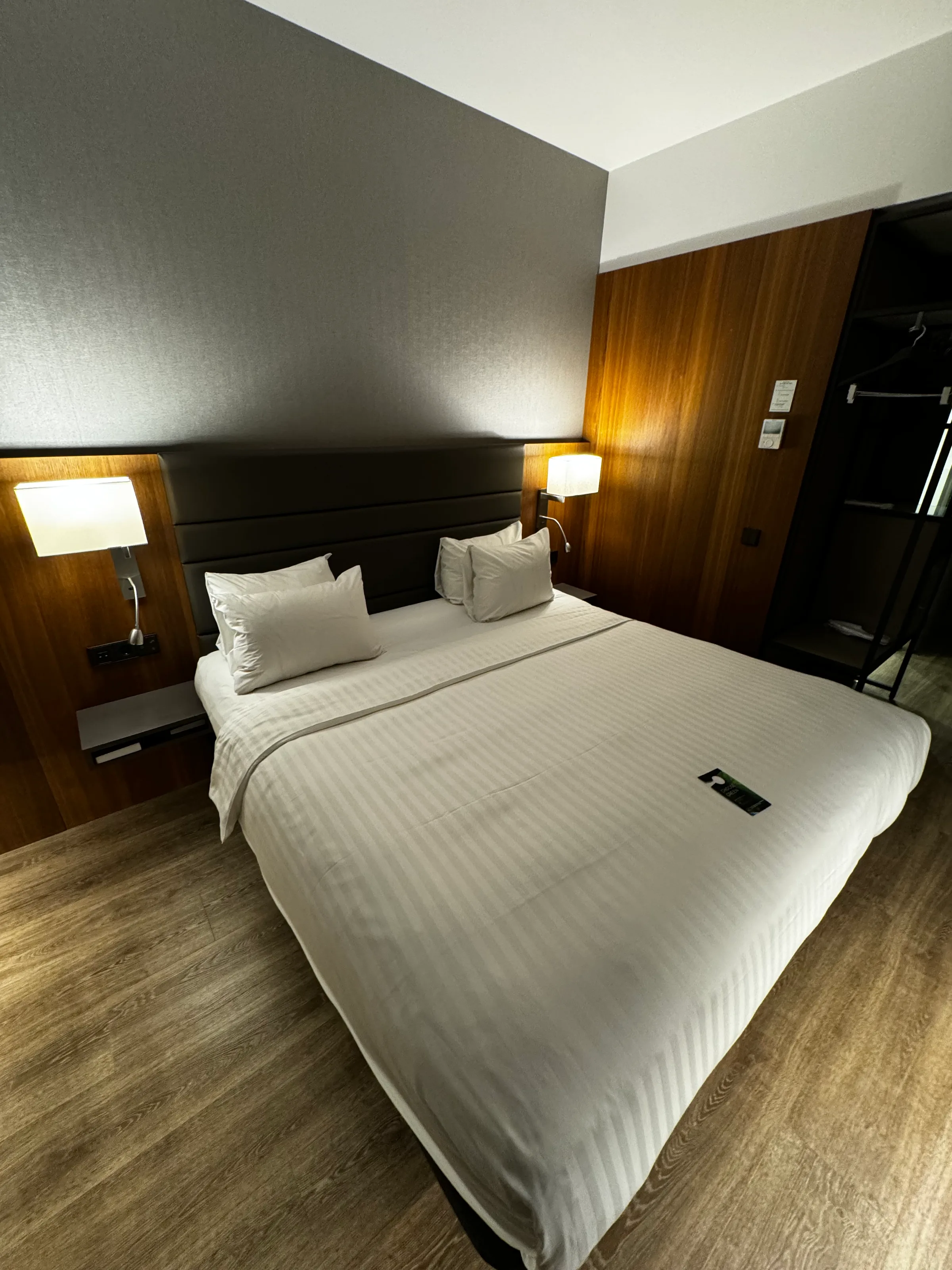 Hotelzimmer mit Doppelbett, Schreibtisch und grüner Wanddekoration