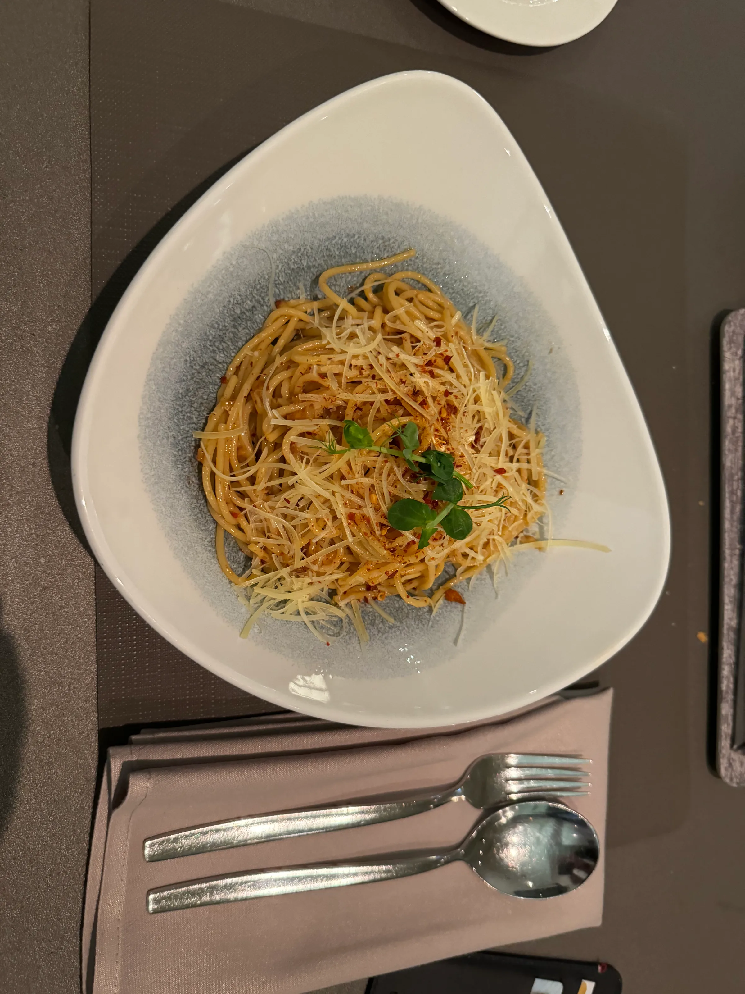 Spaghetti mit Parmesan und Petersilie auf weißem Teller