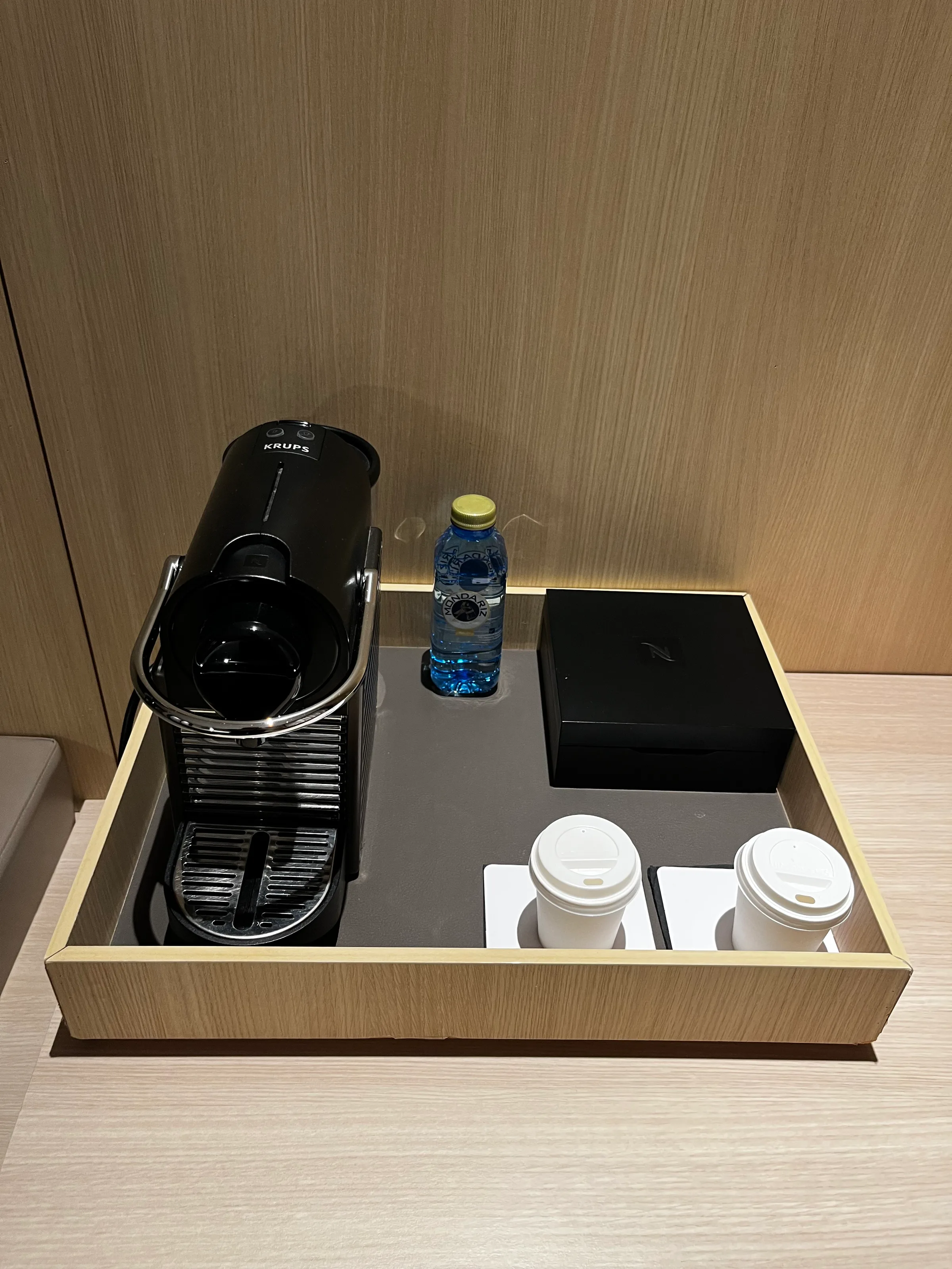 Kaffeemaschine und Getränke auf Holztablett im Hotelzimmer