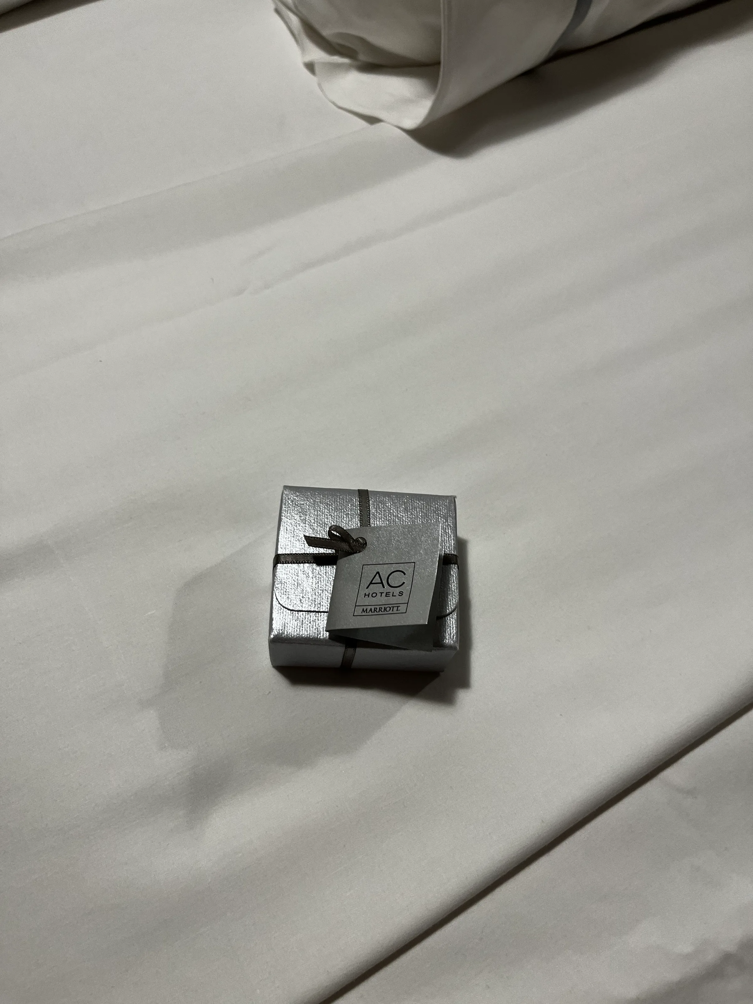 Hotelzimmer mit silberner Box auf weißem Bett
