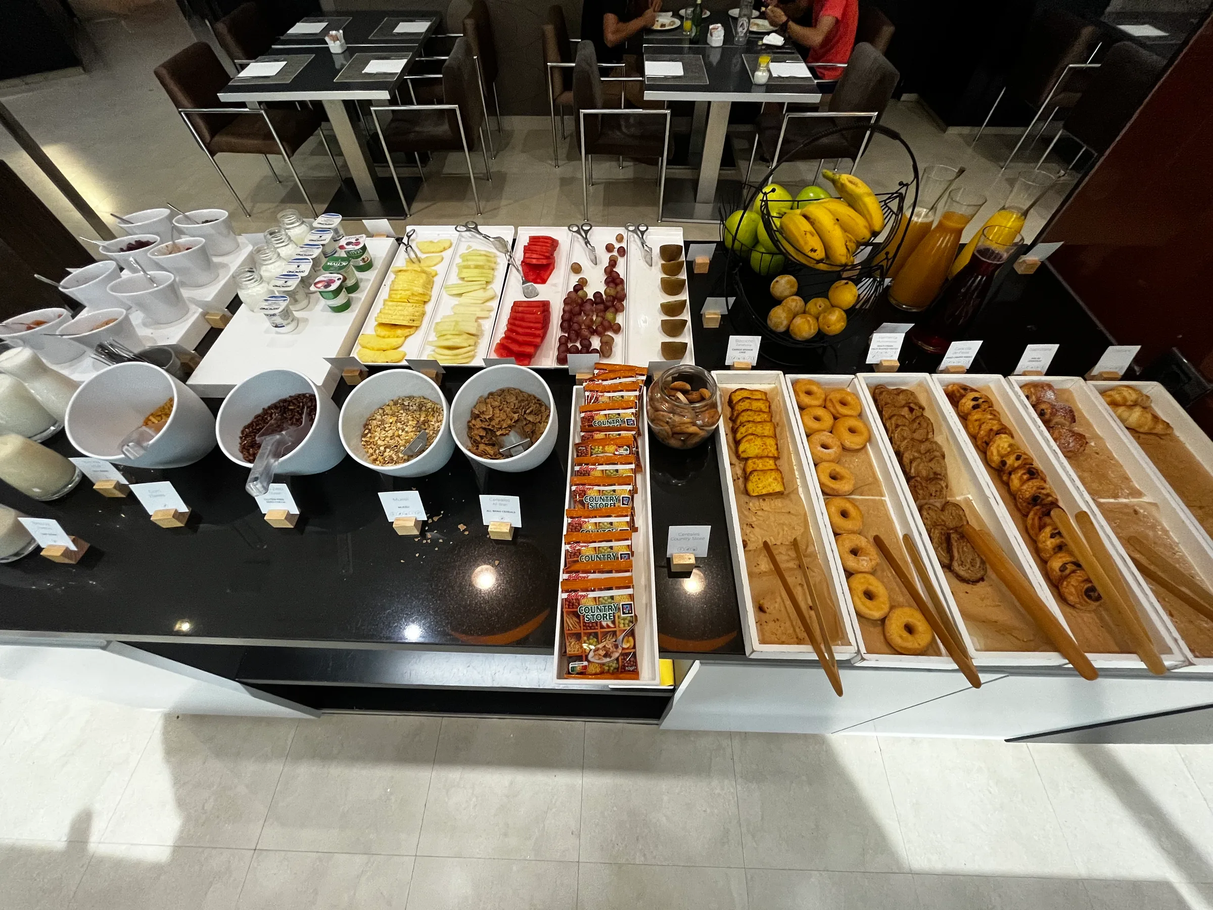Frühstückbuffet mit verschiedenen Gebäcksorten, Obst und Getränken