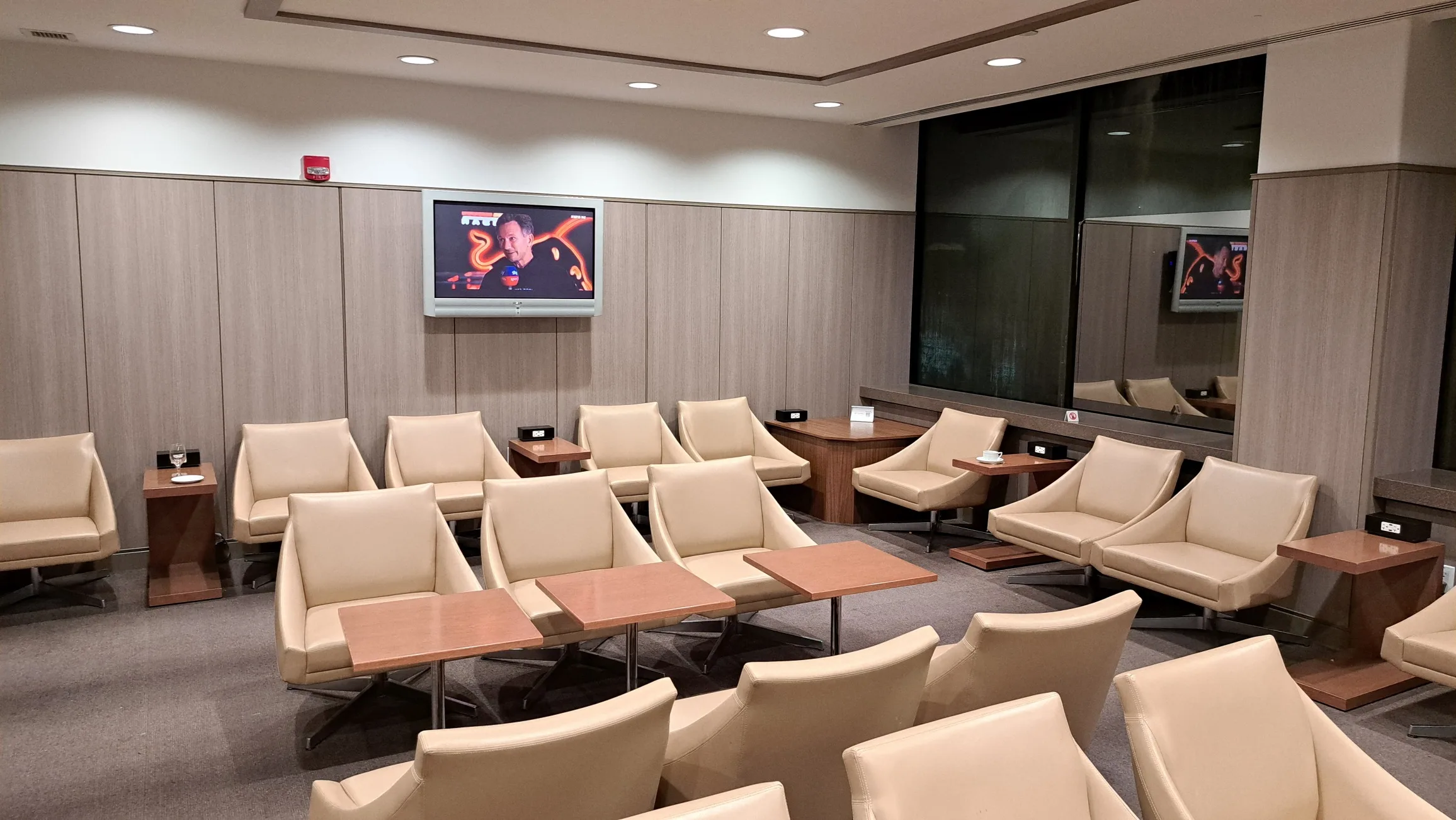 Lounge mit Sesseln und Fernseher an der Wand