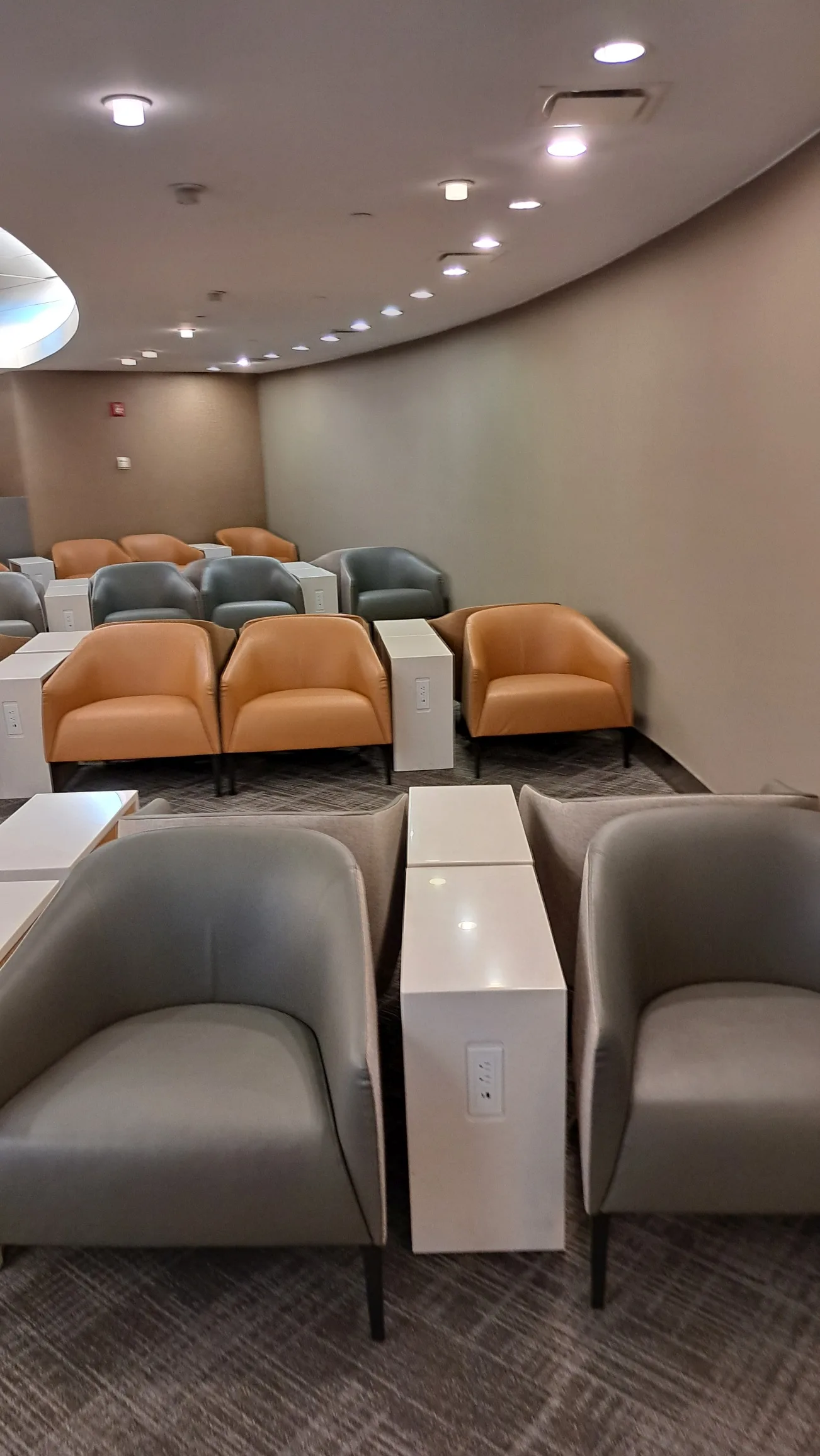 Lounge mit Sesseln und Tischen in warmen Farbtönen