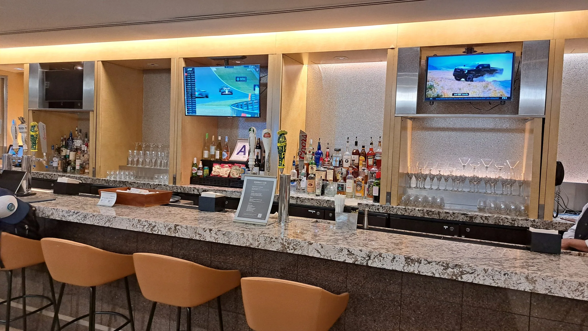 Bar mit Getränken und Fernsehern im Loungebereich
