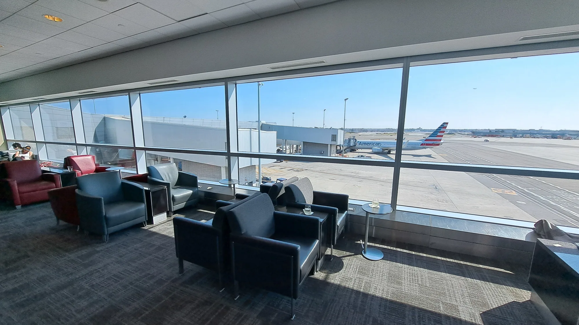 Lounge mit Sesseln und Blick auf Flugzeug am Flughafen