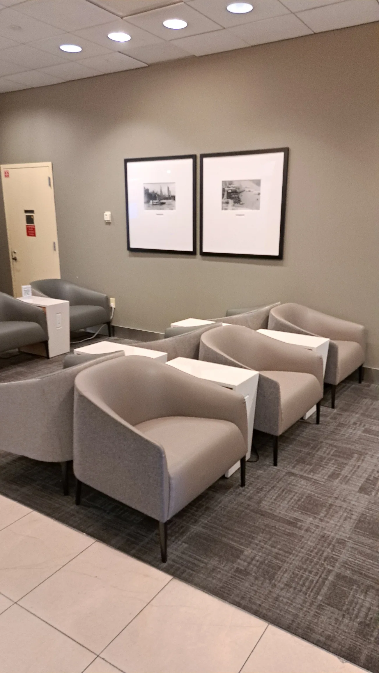 Lounge mit grauen Sesseln und Bildern an der Wand