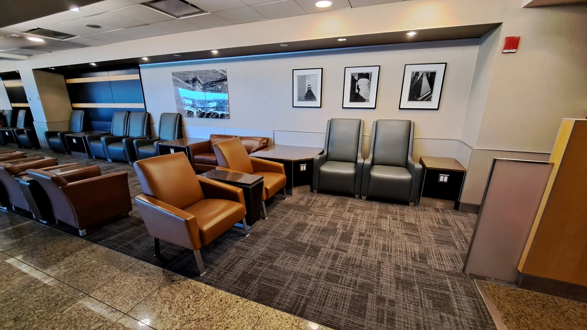 Lounge mit Sesseln und Tischen in neutralen Farben