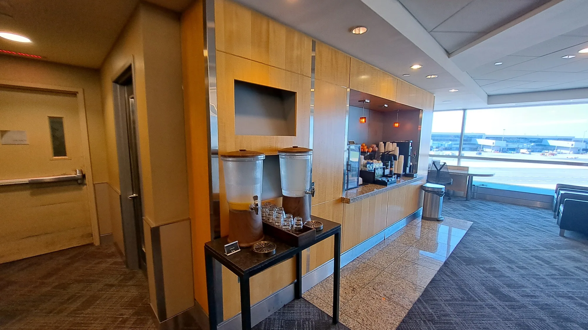 Flughafen-Lounge mit Getränkeautomaten und Ausblick auf die Startbahn