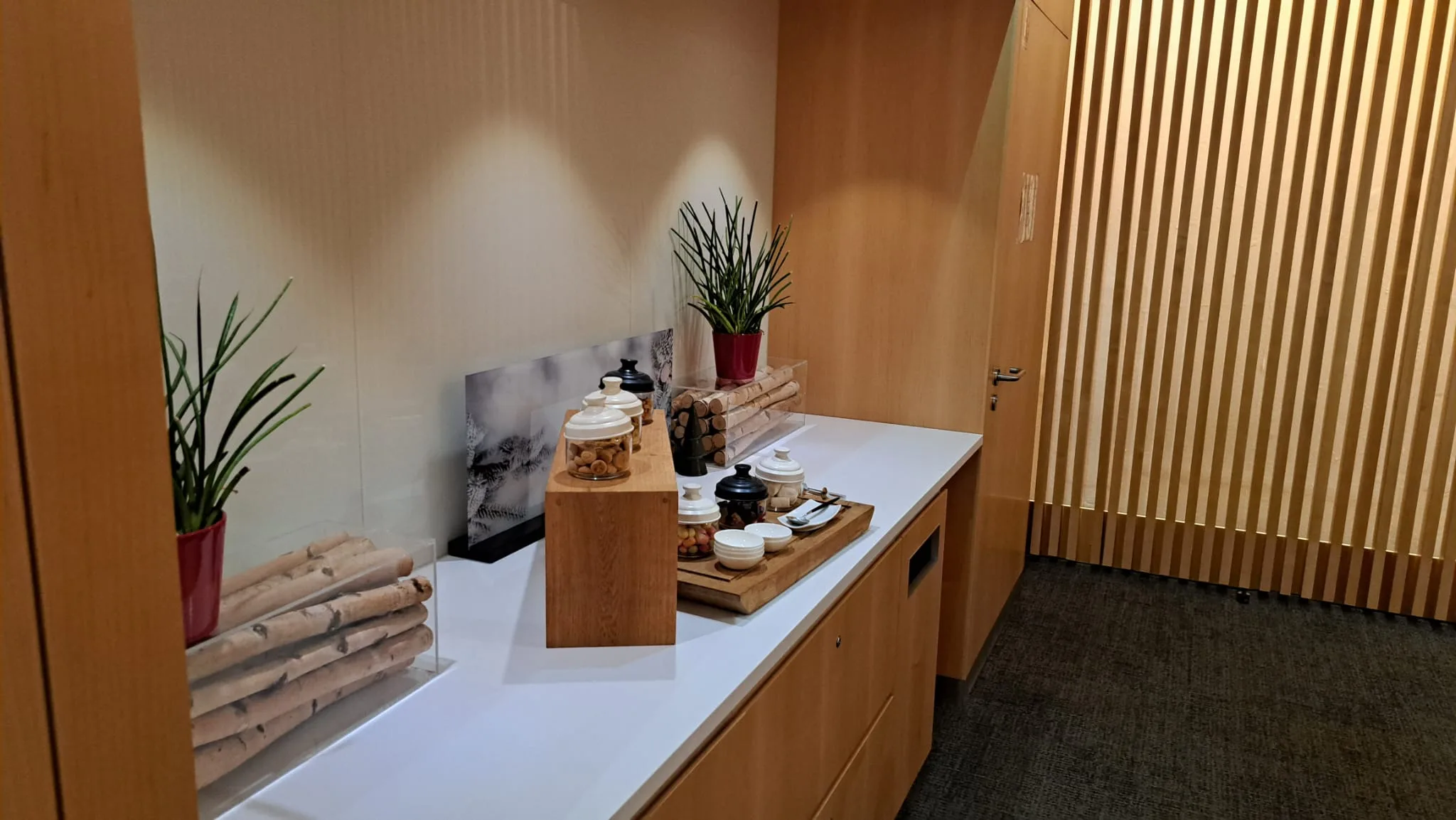 Lounge mit Pflanzen und Teeservice auf Holzsockel