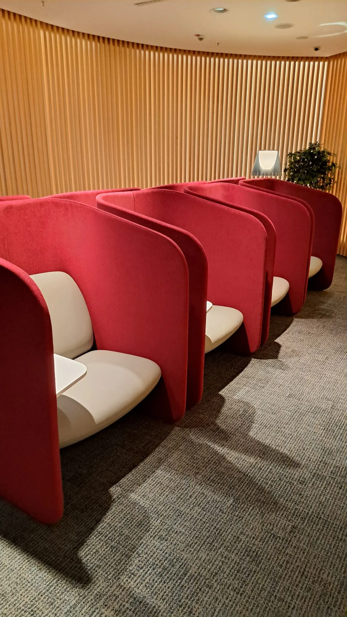 Reihen von roten Sesseln mit weißen Polstern in einem Flughafensalon