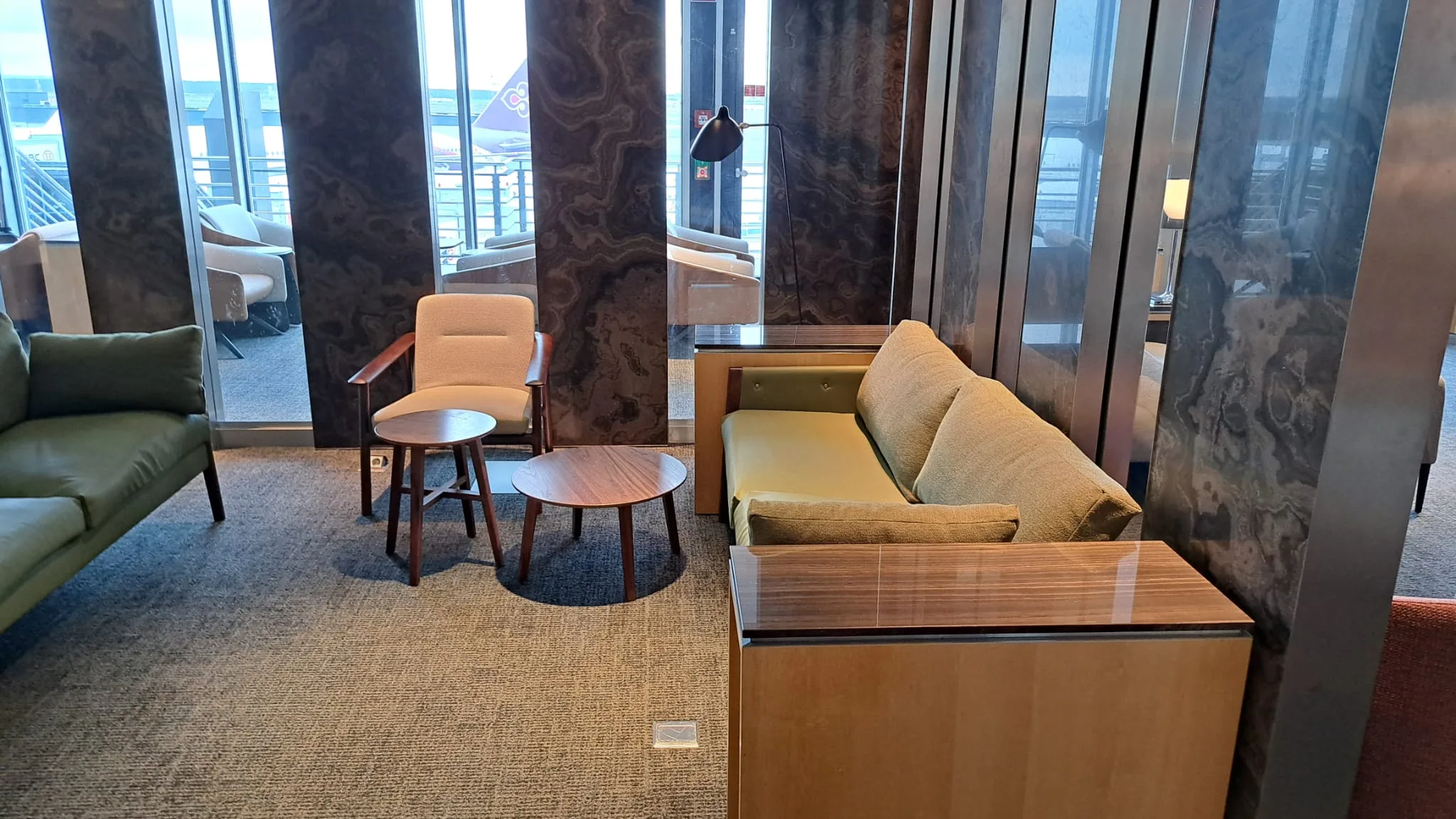 Lounge mit Sesseln und Couch in Grautönen