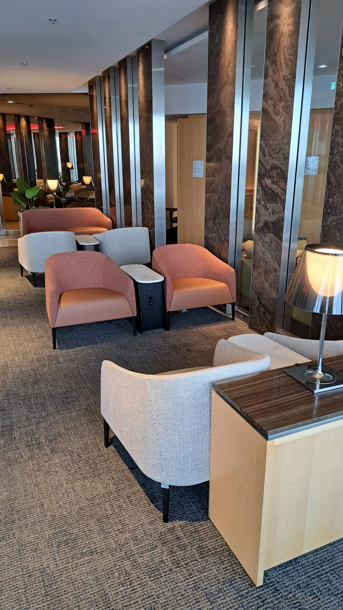 Lounge mit Sesseln und Tischen in warmen Farbtönen