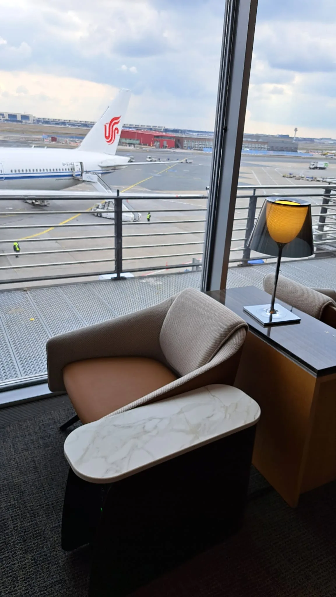 Lounge-Sessel mit Tisch und Lampe am Flughafenfenster