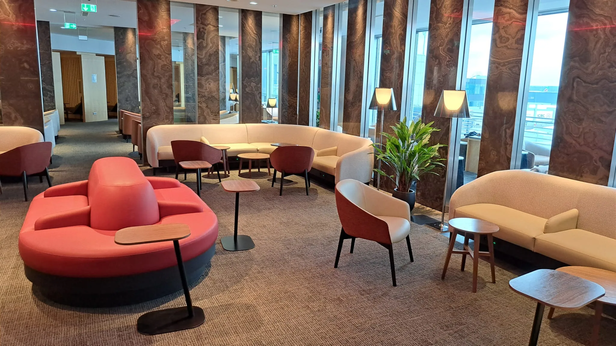 Runde Sitzgruppe mit roten und weißen Sofas in einem modernen Loungesaal