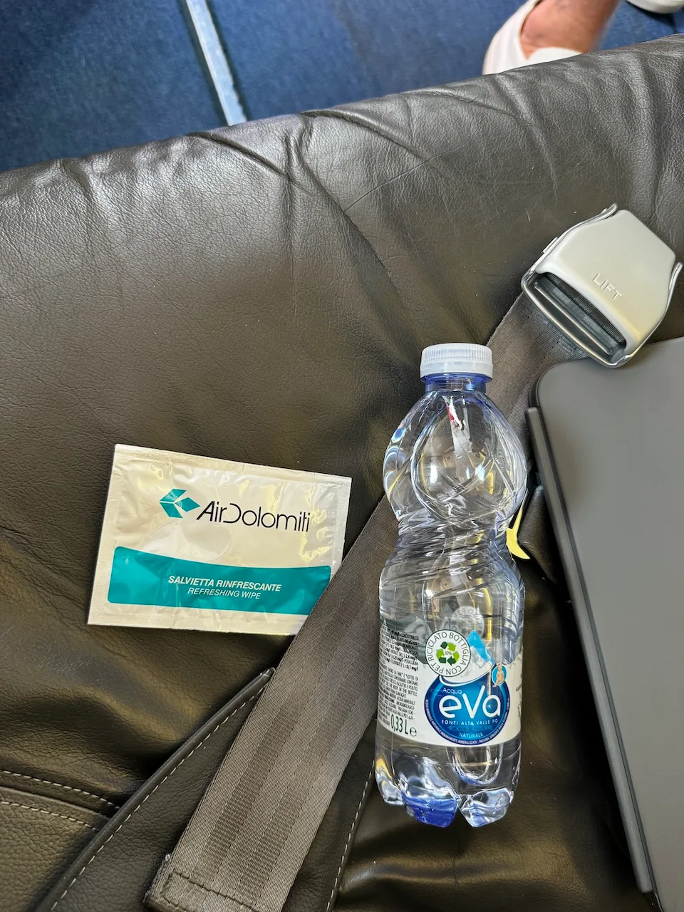 Flugzeugkabinenarmlehne mit Wasserflasche und Serviette