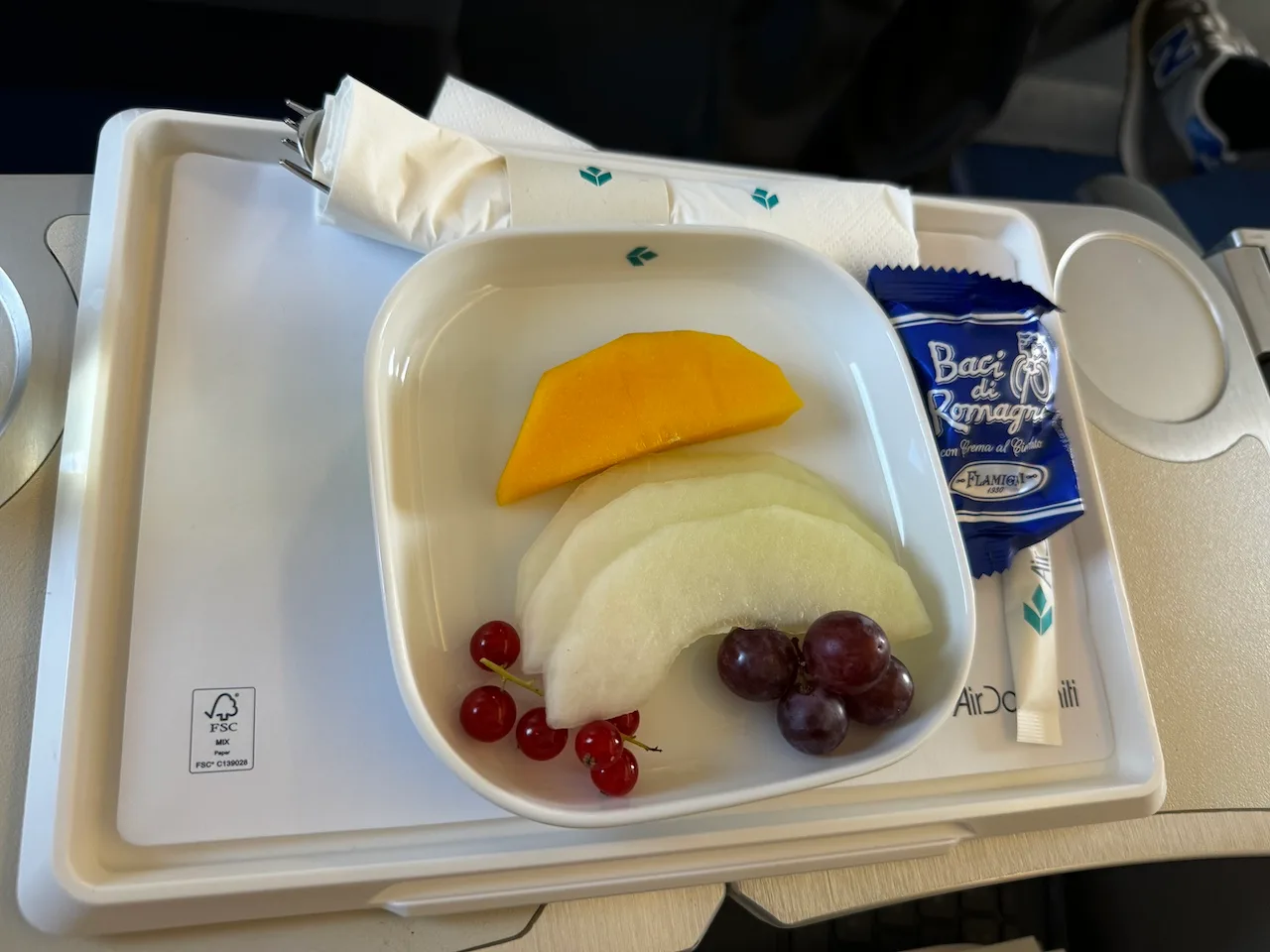 Fruchtschale mit Mango, Melone, Johannisbeeren und Trauben auf Tablett