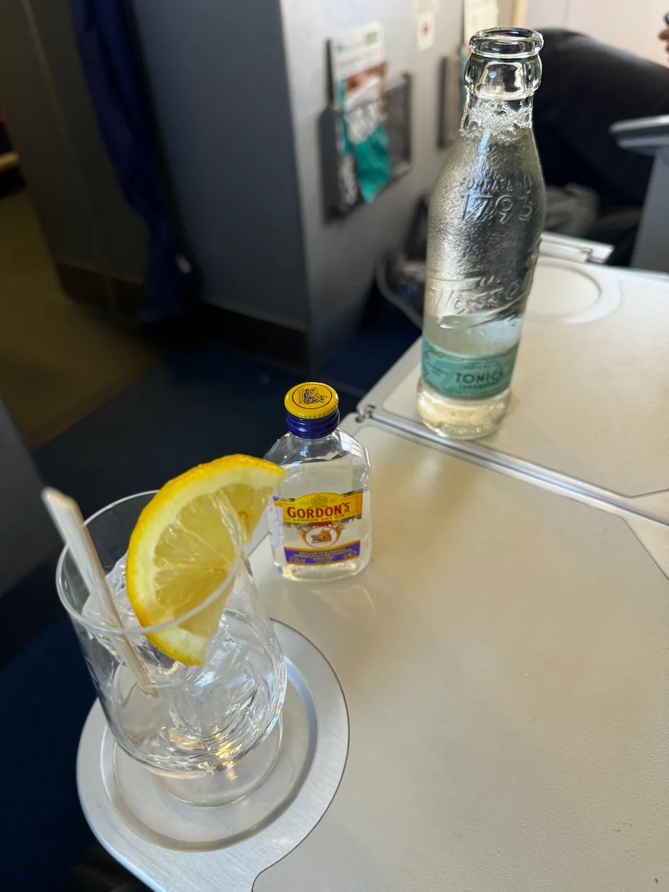 Gin-Tonic mit Zitrone auf Tisch in Business Class
