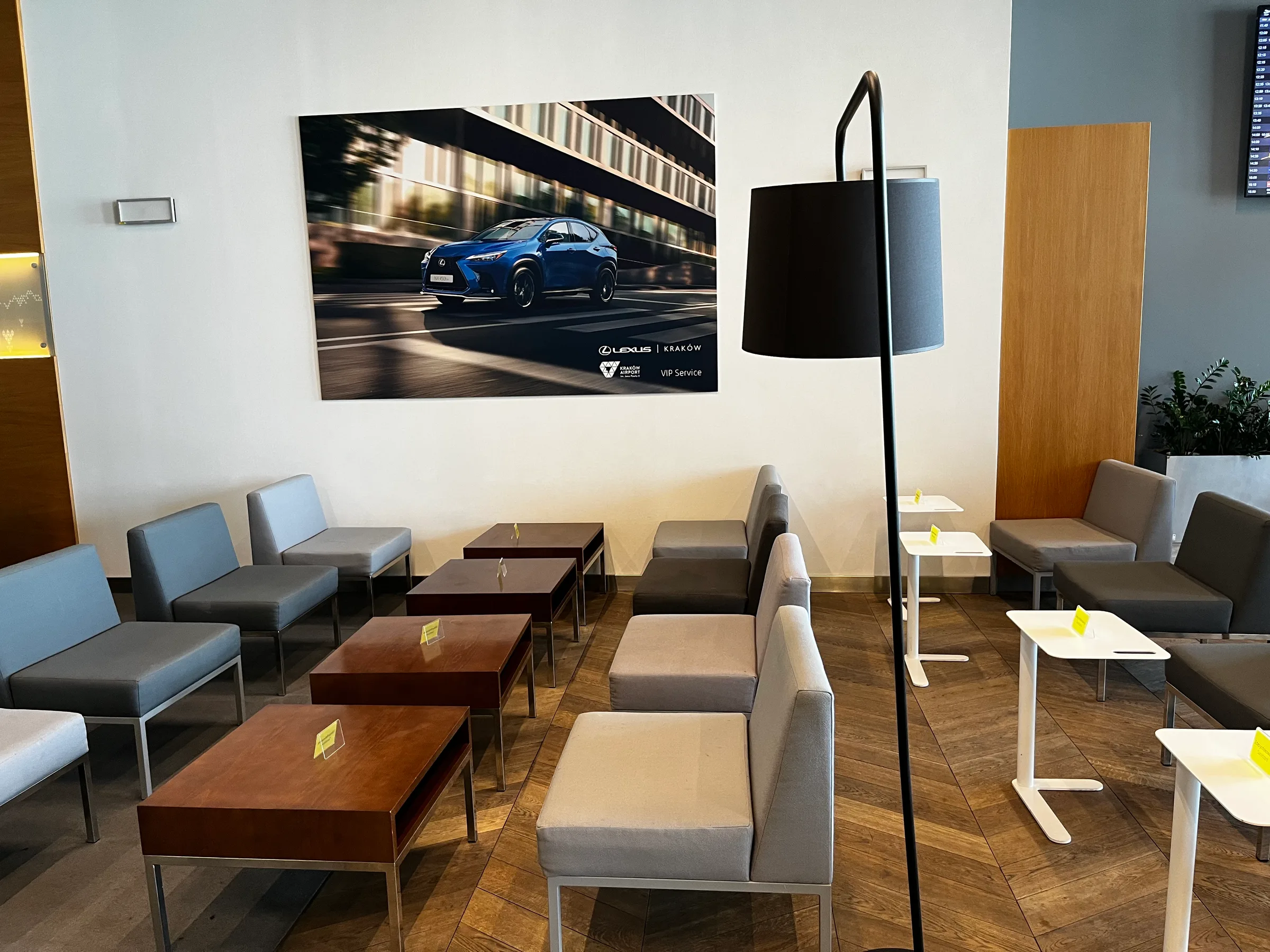 Lounge mit Sesseln und Couchen sowie Werbung für Lexus in der Wand