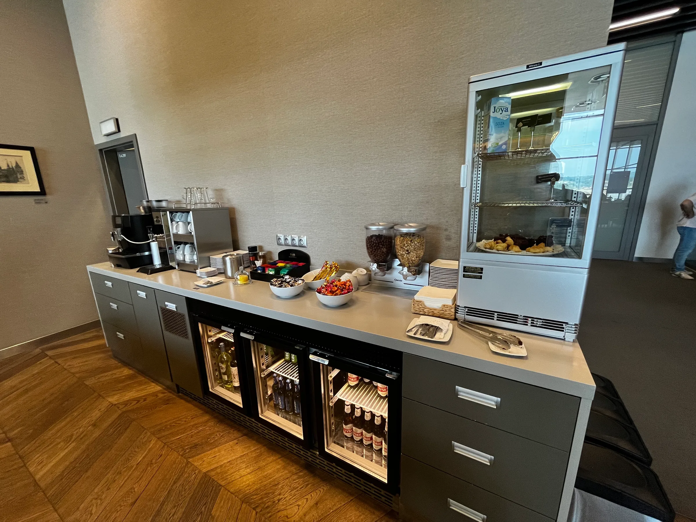Business-Lounge-Ausstattung mit Kaffeevollautomat, Getränkekühlschränken und Snackbuffet