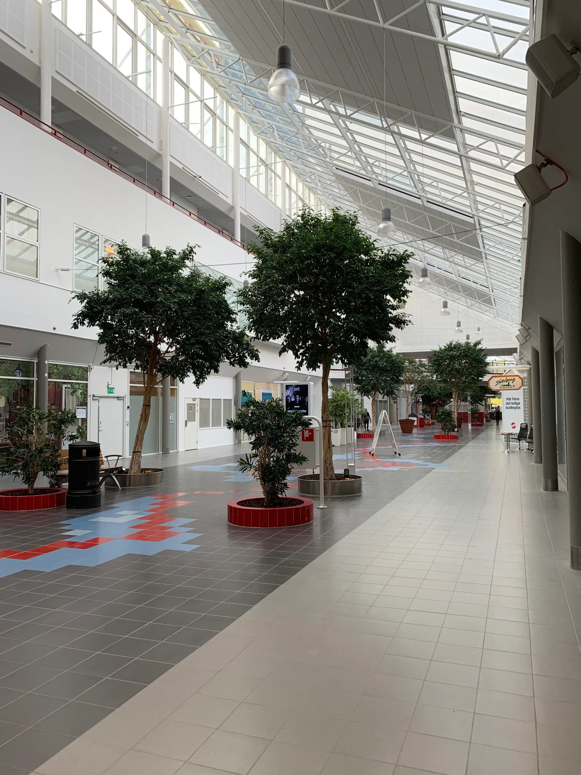 Lobby mit Bäumen und Sitzgelegenheiten