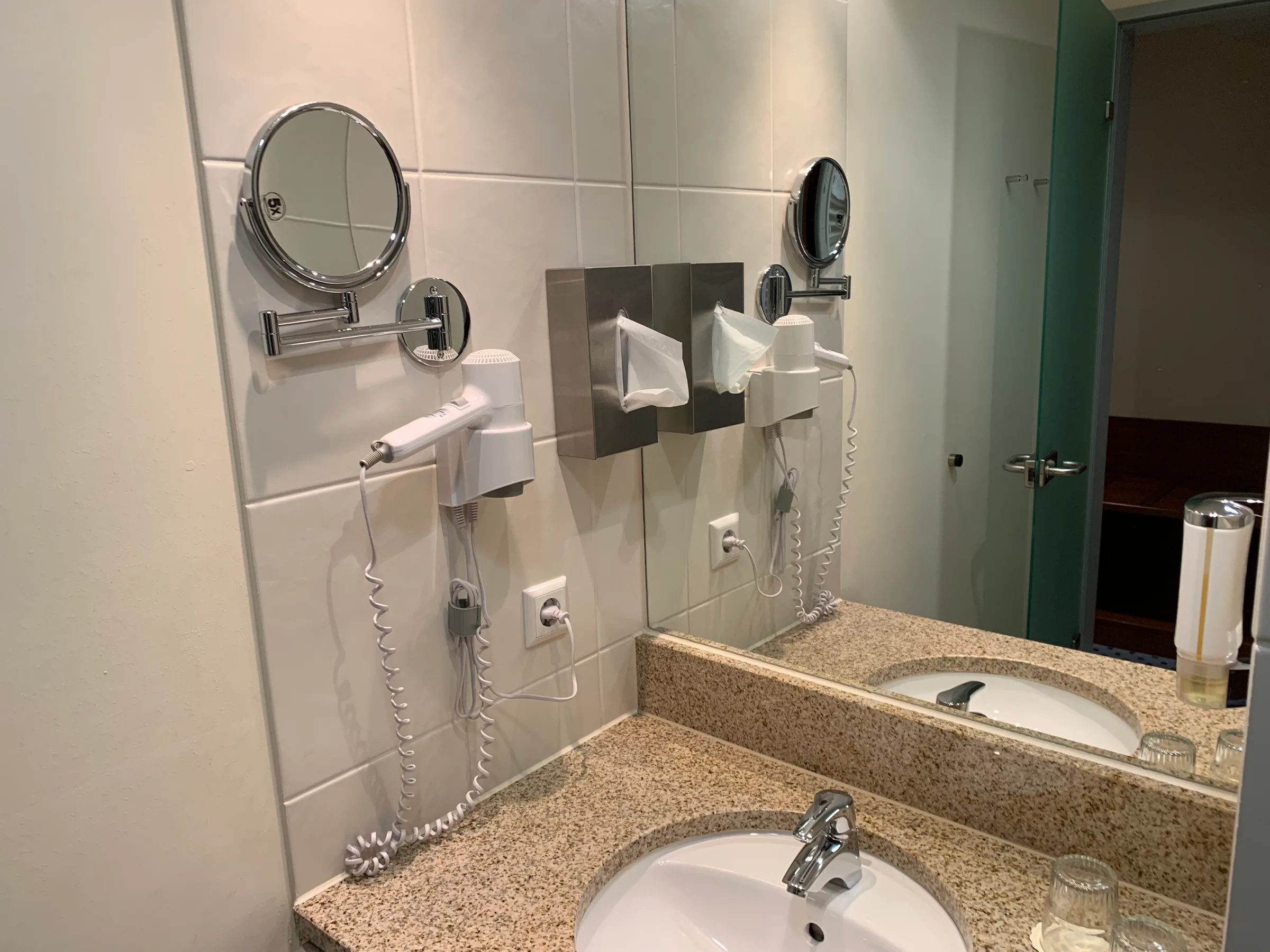 Hotelbadezimmer mit Waschbecken, Spiegeln und Handtuchhalter