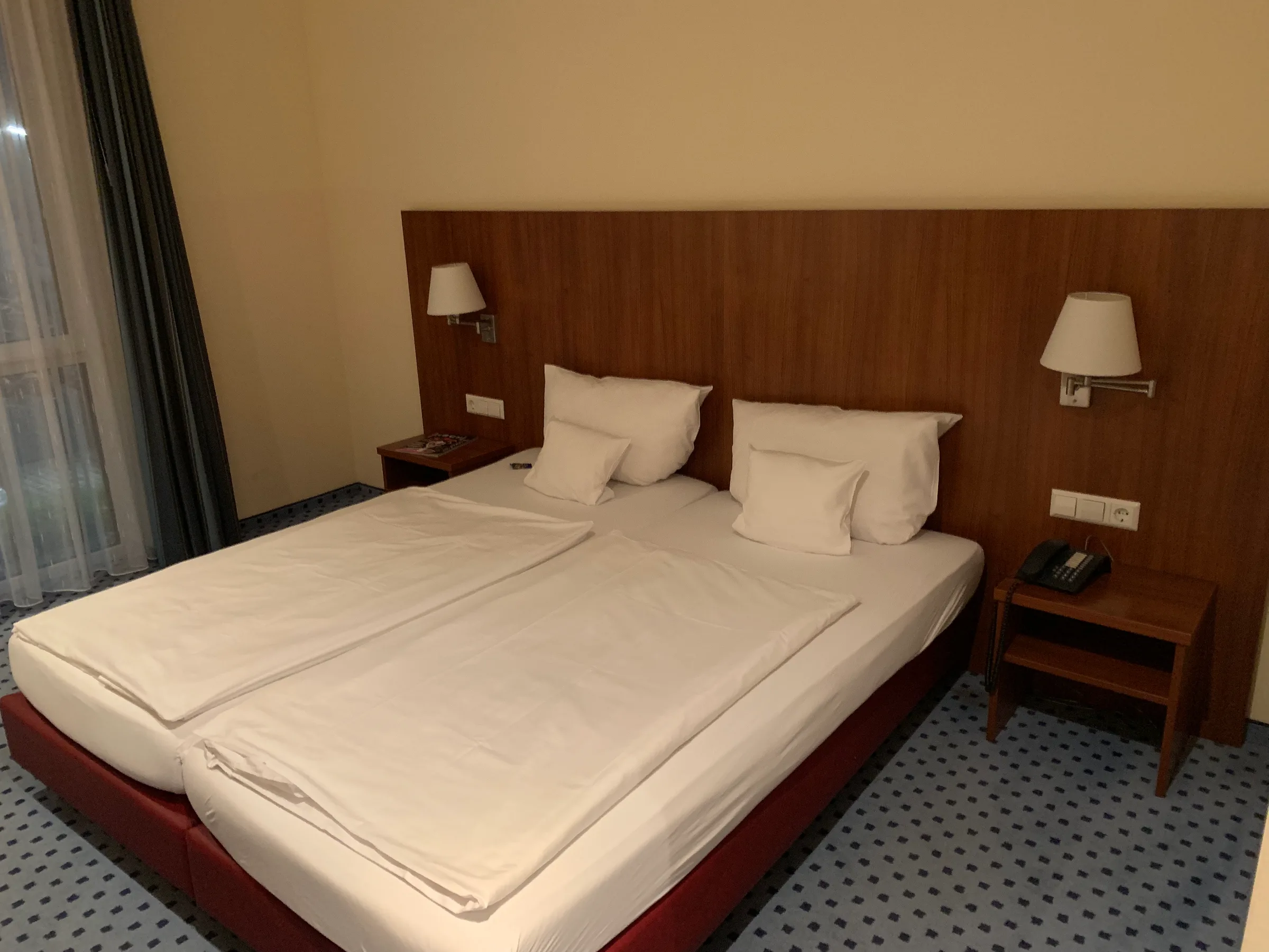 Hotelzimmer mit Doppelbett und Nachttischen