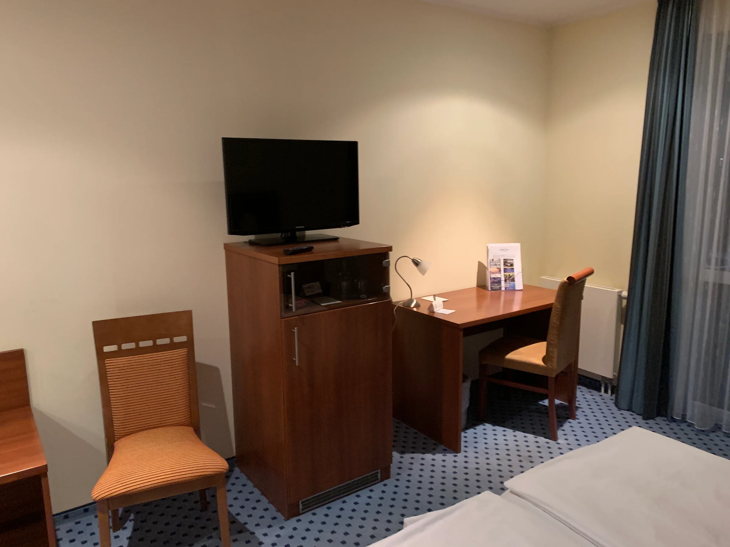 Hotelzimmer mit Schreibtisch und Fernseher