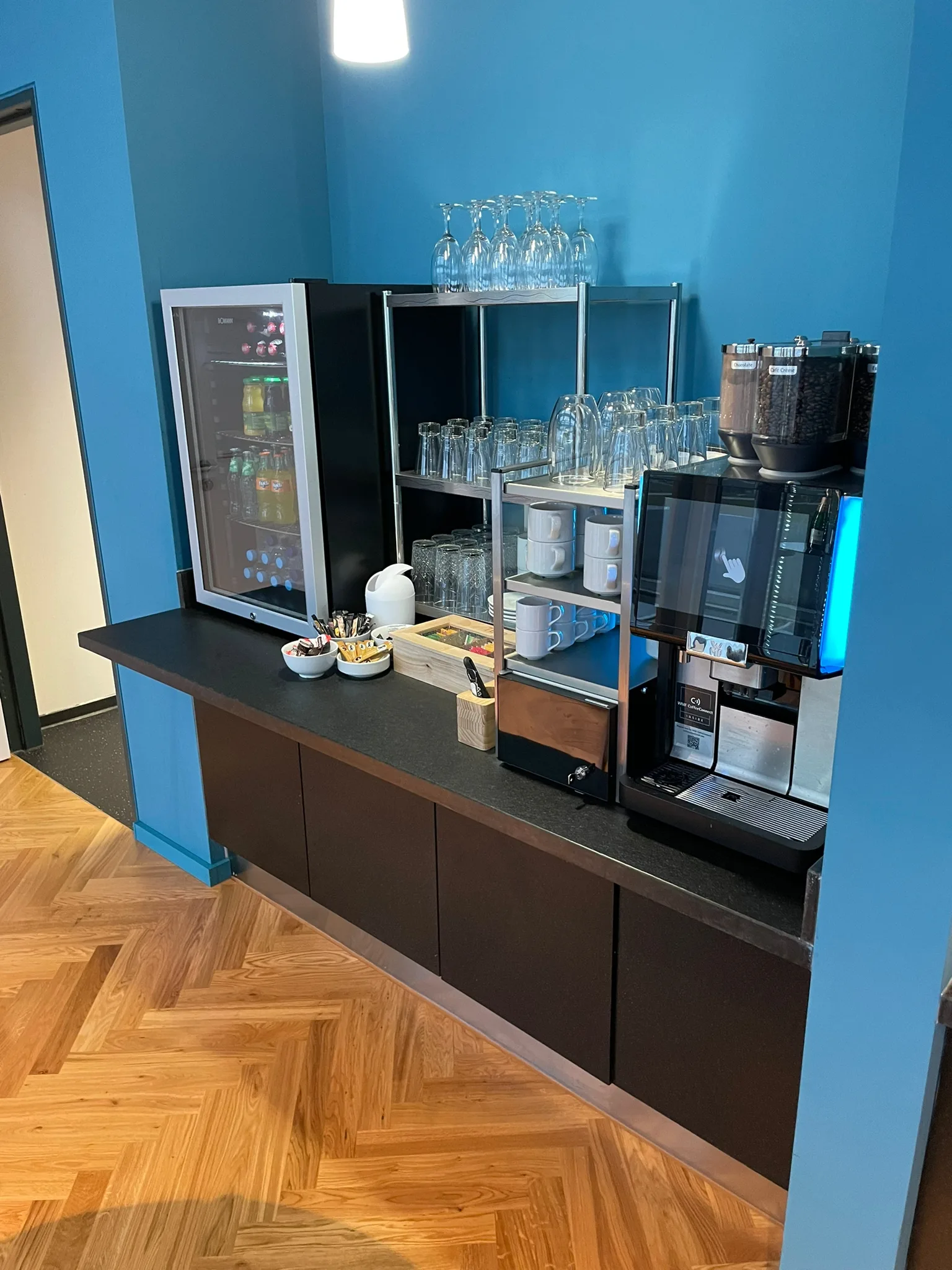 Flughafenlounge mit Kühlschrank, Gläsern und Kaffeemaschine