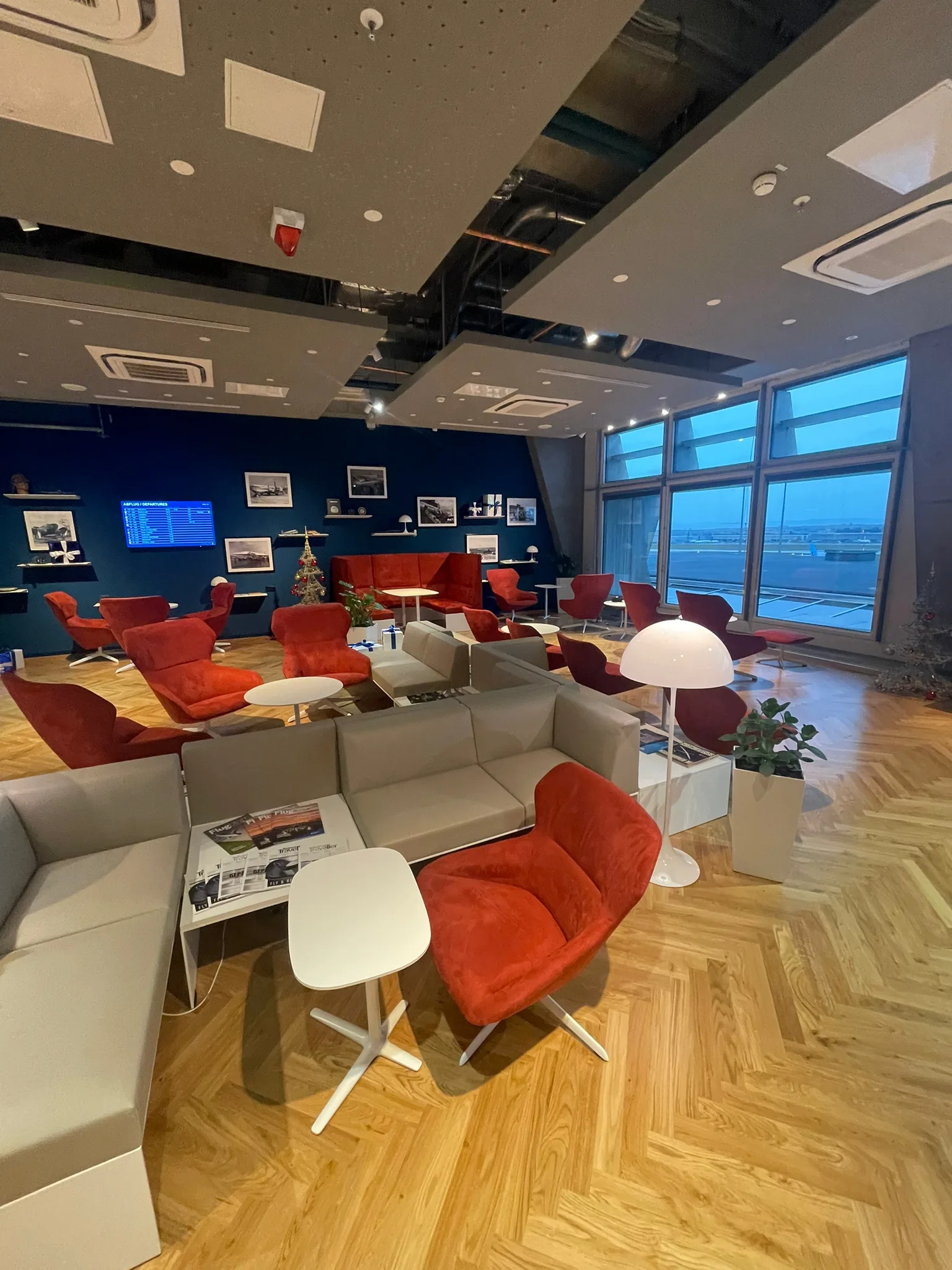 Lounge mit roten Sesseln und Couchen im Flughafen Stuttgart