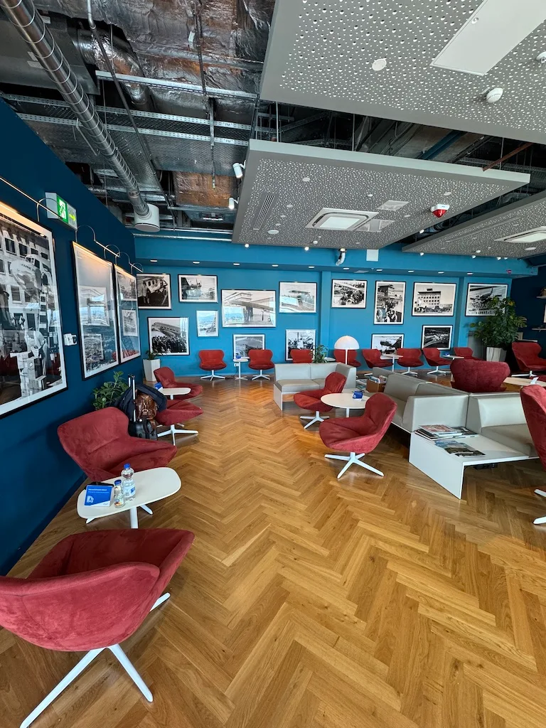 Lounge mit roten Sesseln und blauer Wand mit Bildern