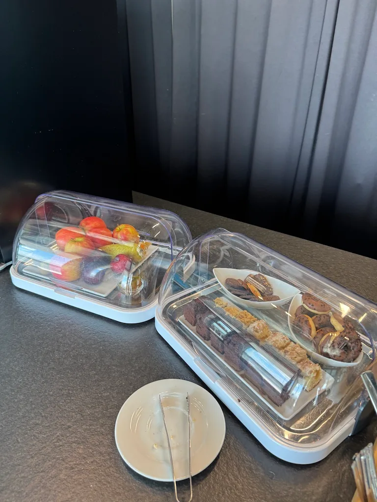 Fruchtschalen und Gebäck in Schutzkästen auf Tisch