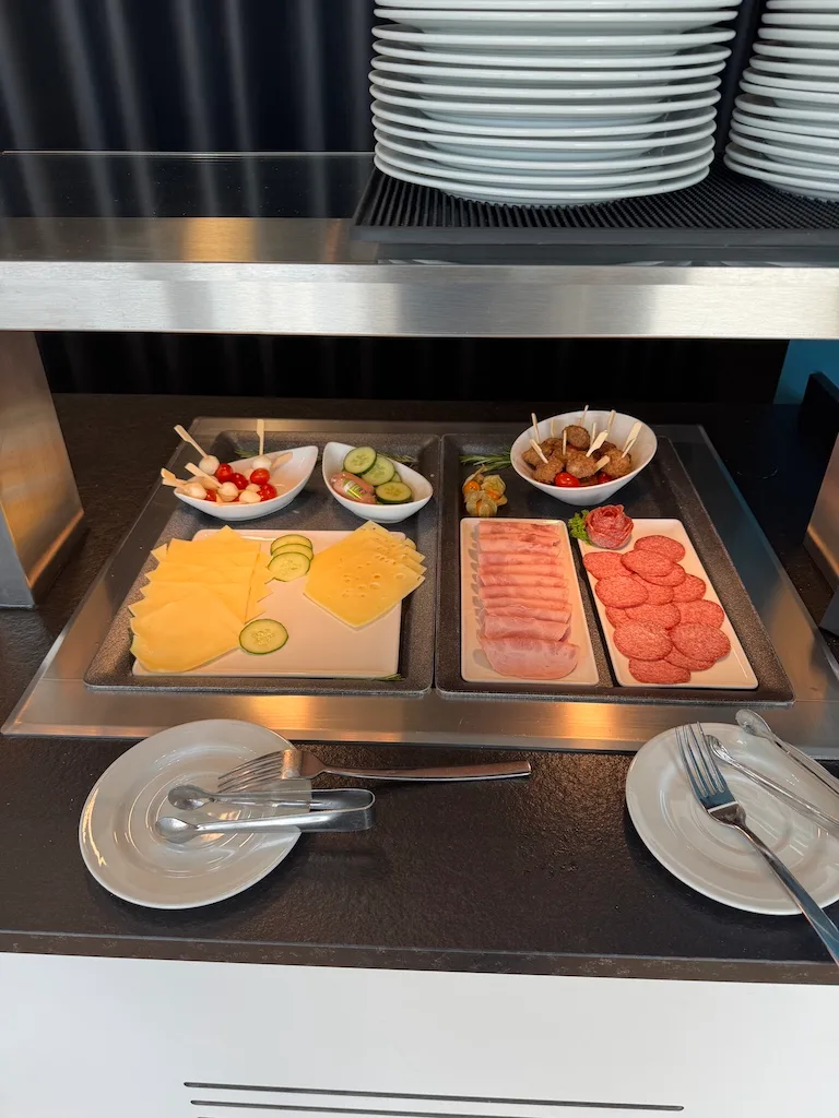 Buffet mit Käse, Schinken und Gemüse auf Holzbrettern