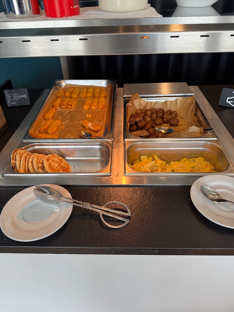 Buffet mit verschiedenen Gerichten wie Käsestäbchen, Fleischkugeln und Kartoffelpüree