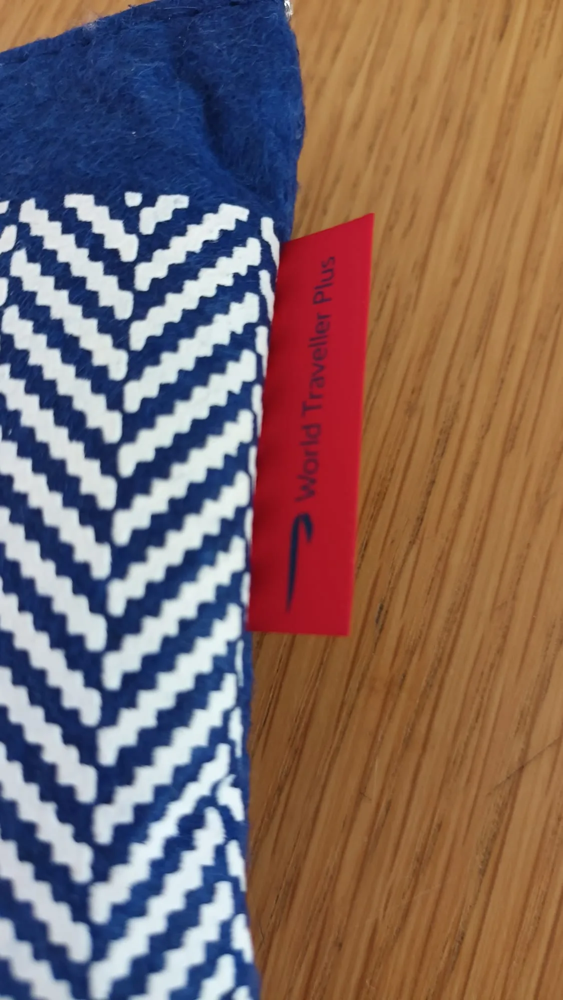 Blauer Stoff mit weißer Zickzack-Muster und rotem Etikett