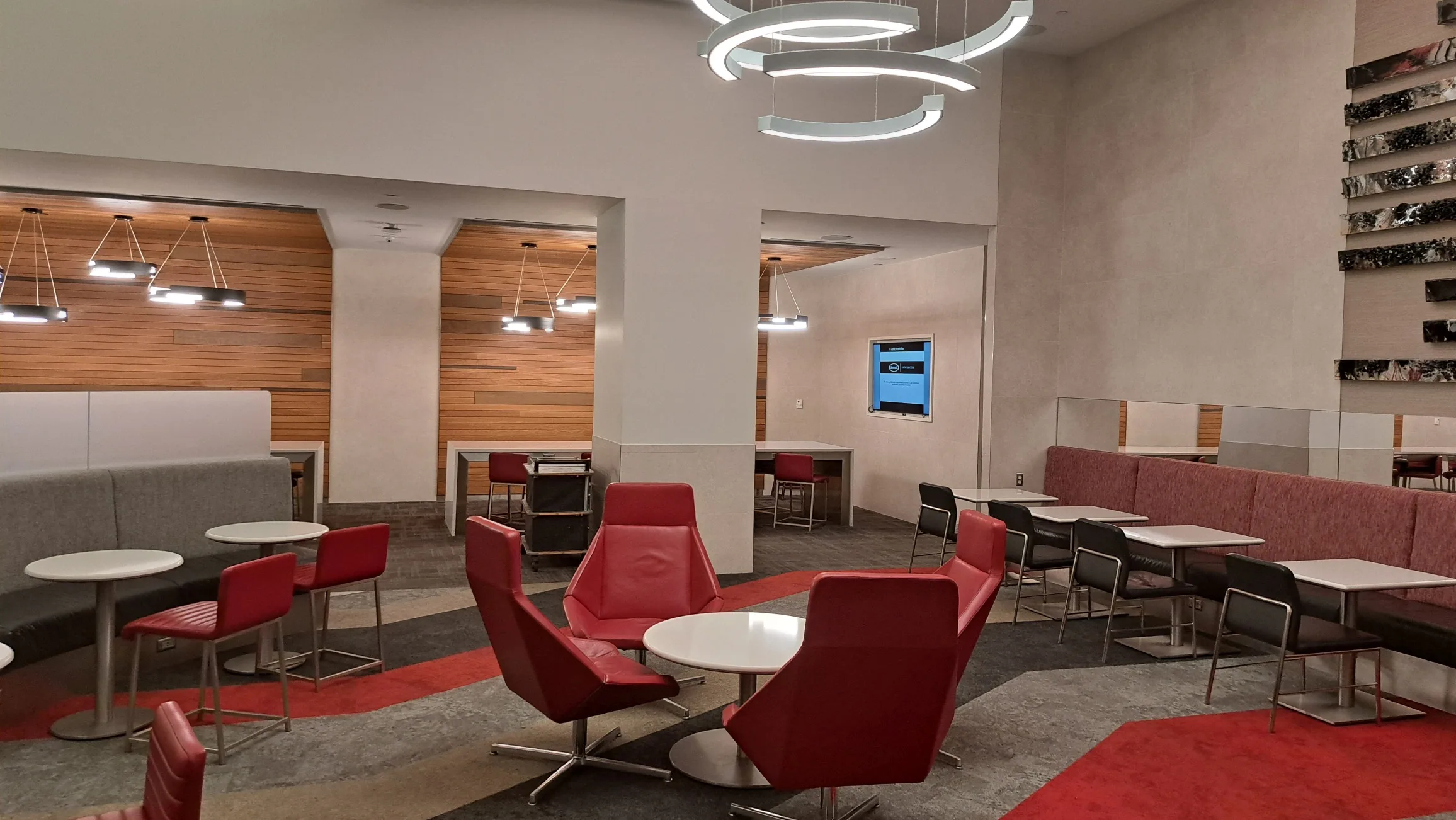 Lounge mit roten Stühlen und grauen Polstermöbeln