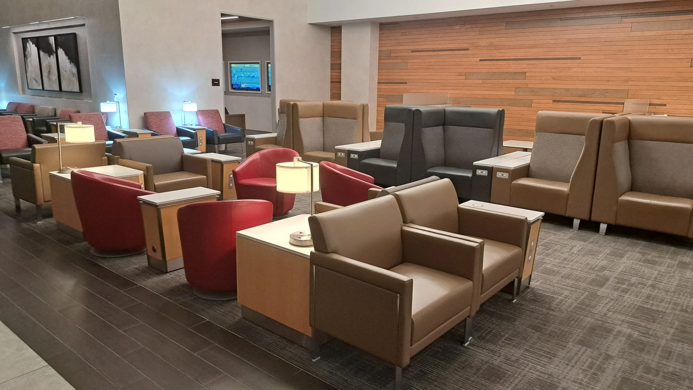 Lounge mit Sesseln und Tischen in warmen Farbtönen