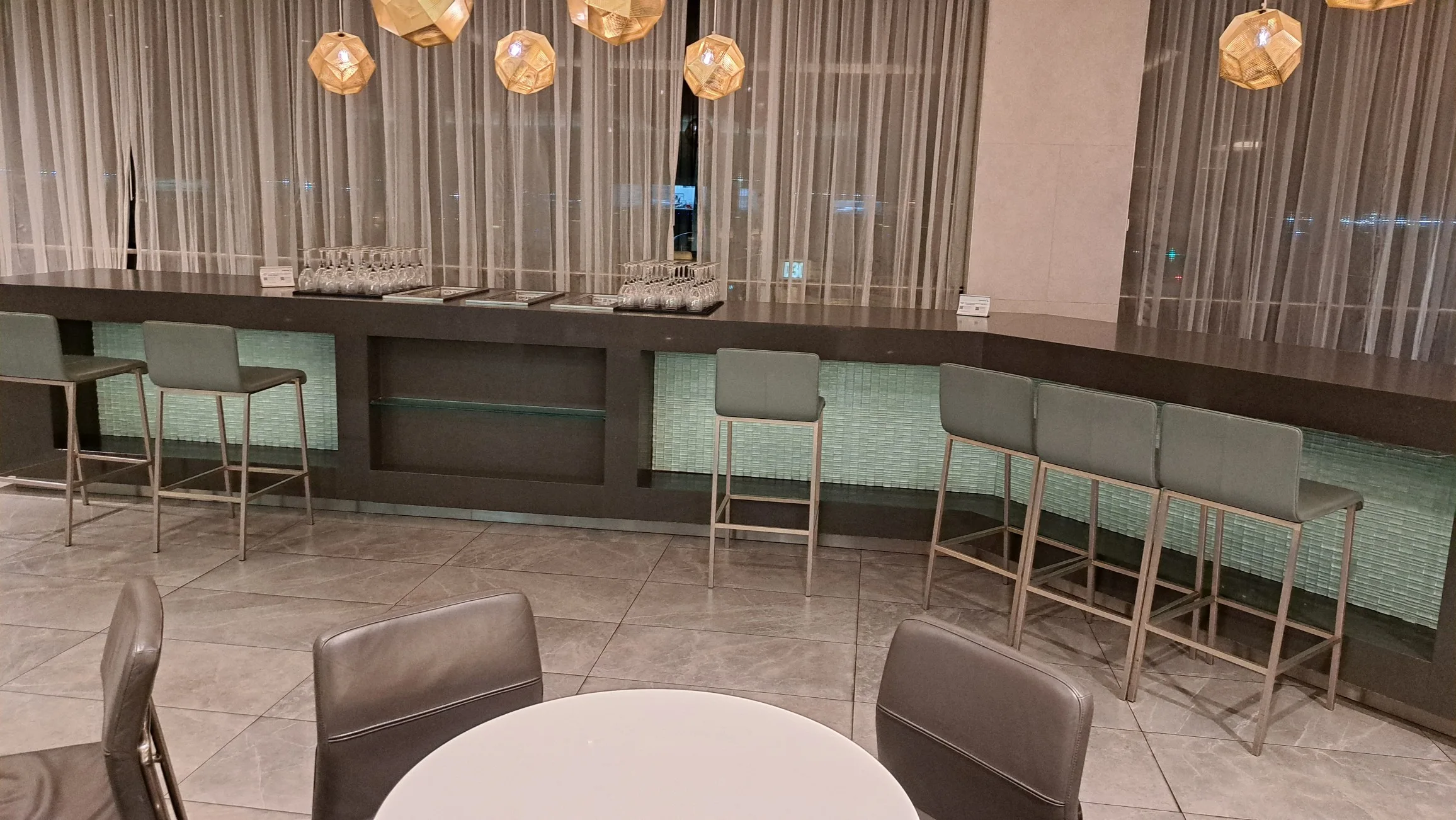 Bar mit Stühlen und Gläsern im Flughafenlounge