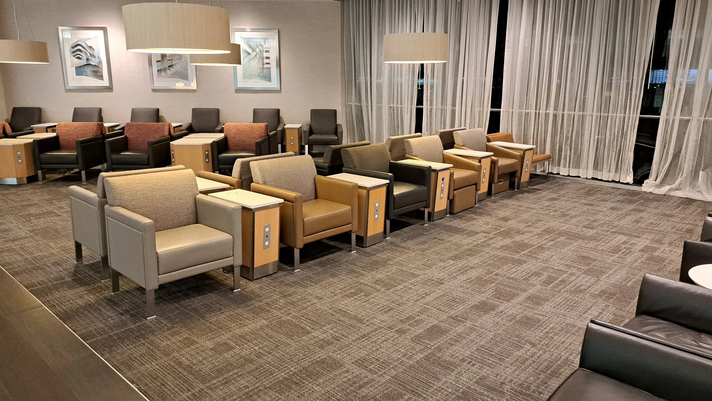 Lounge mit Sesseln und Tischen in neutralen Farben