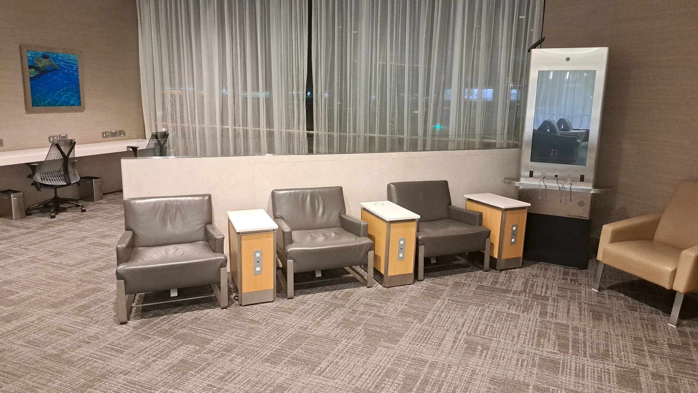 Lounge mit Sesseln und Tischen in neutralen Farben