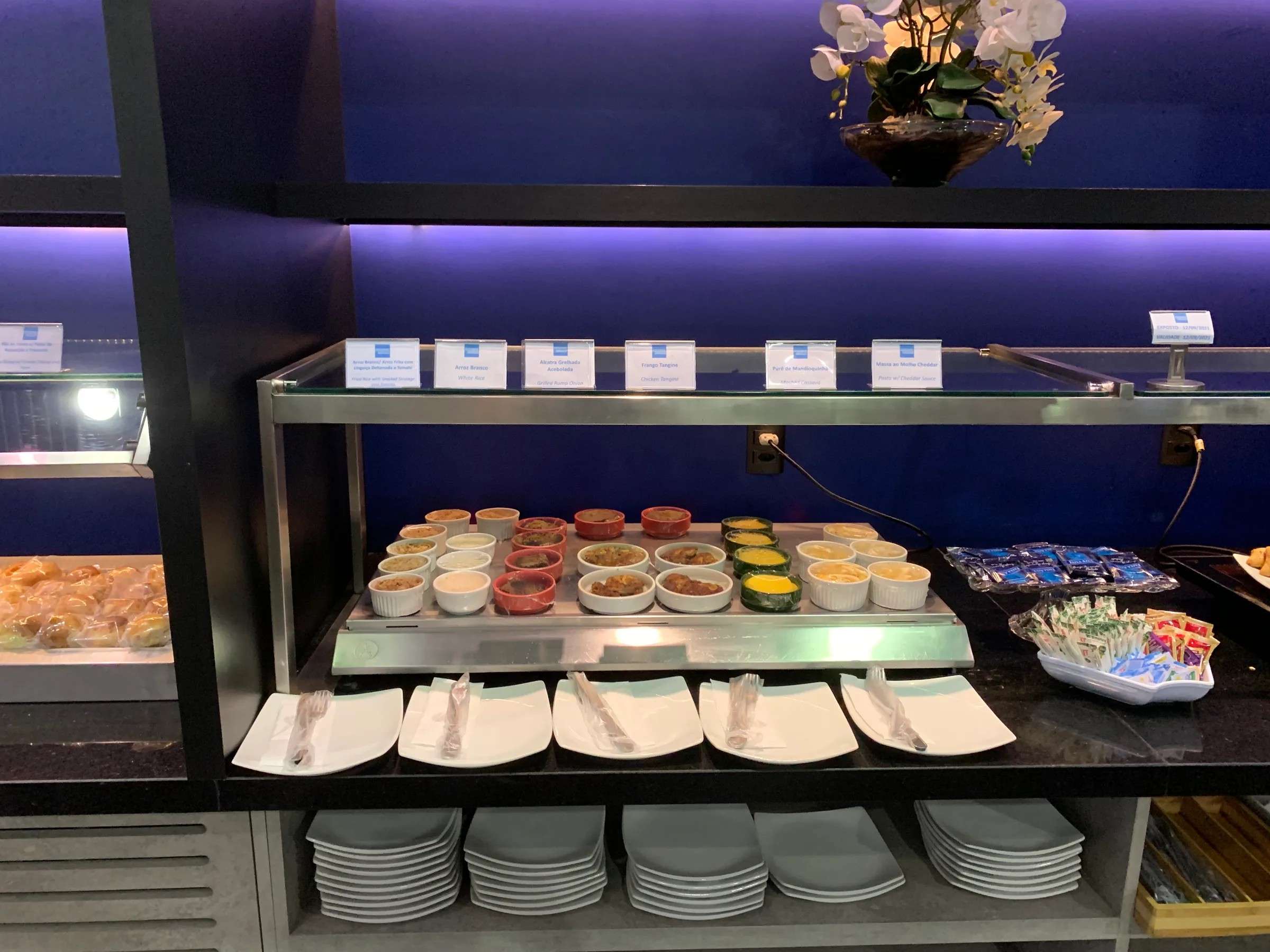 Buffet mit verschiedenen Beilagen und Tassen auf Regal