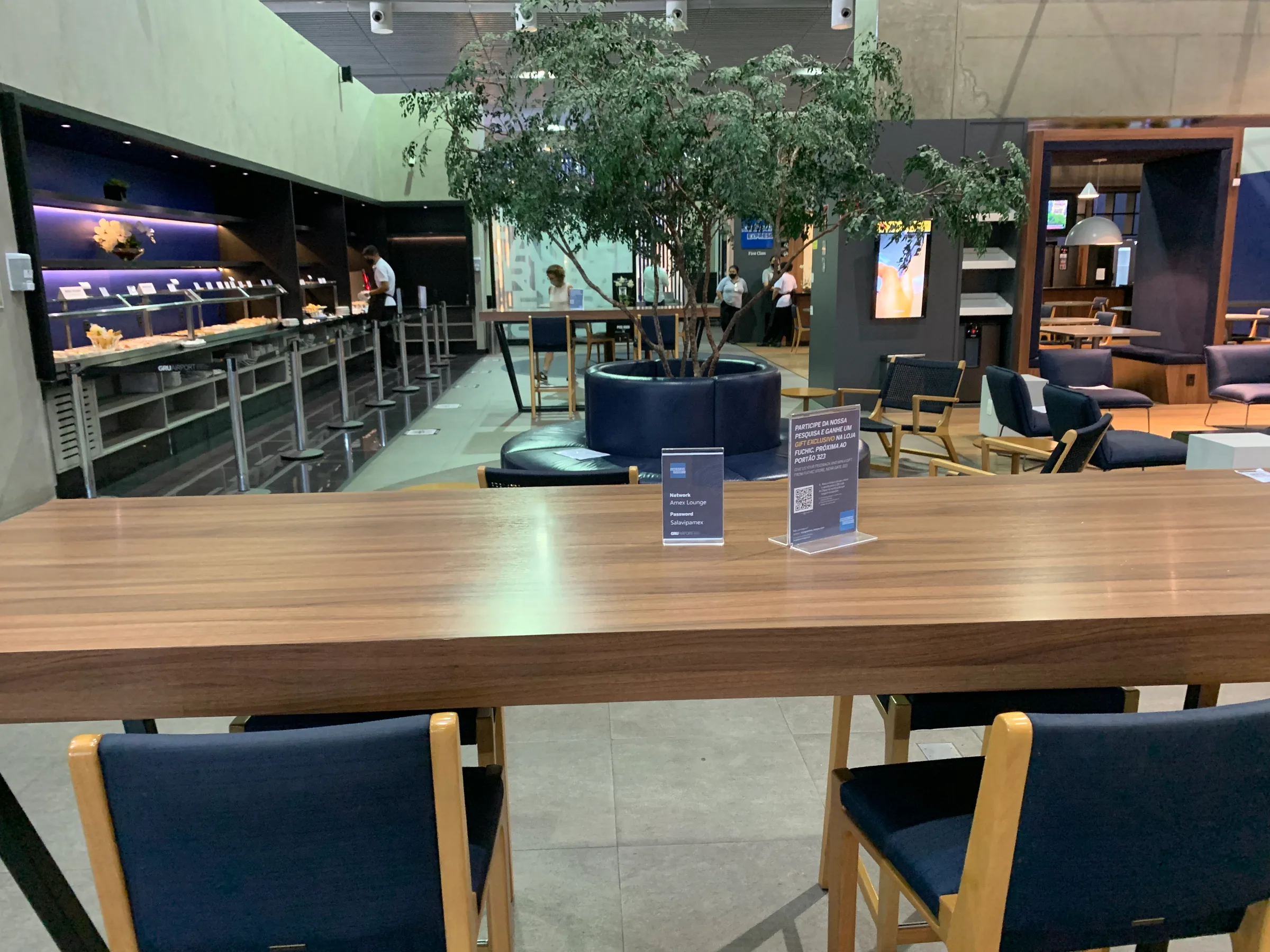 VIP-Lounge mit Holztischen und blauen Stühlen