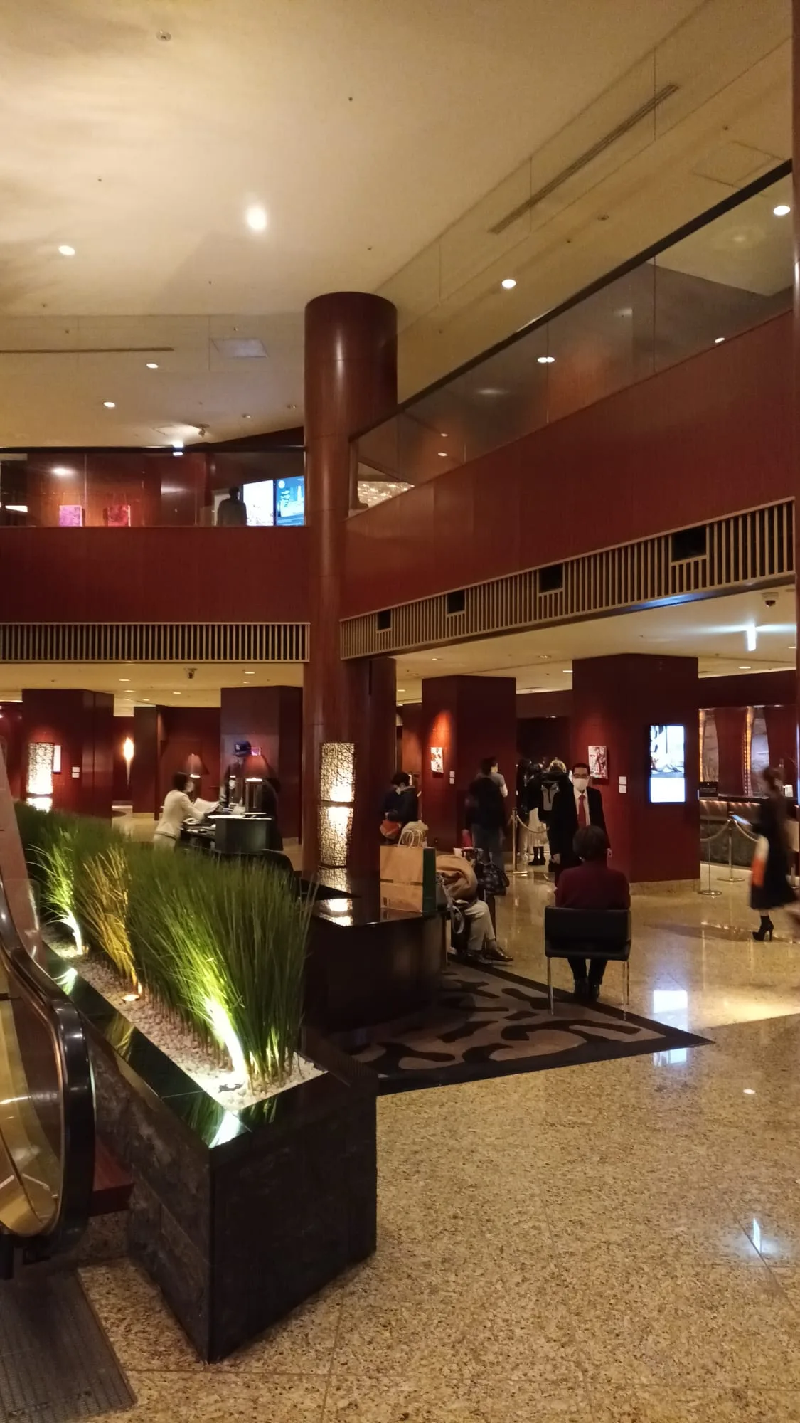 Lobby eines Hotels mit Säulen und Pflanzenbeeten
