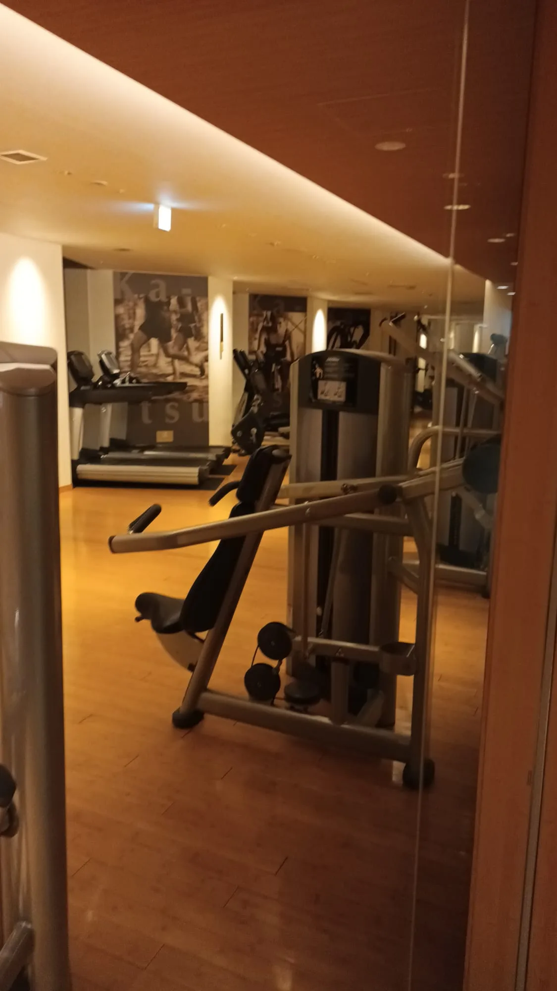 Fitnessraum mit Trainingsgeräten und Holzboden
